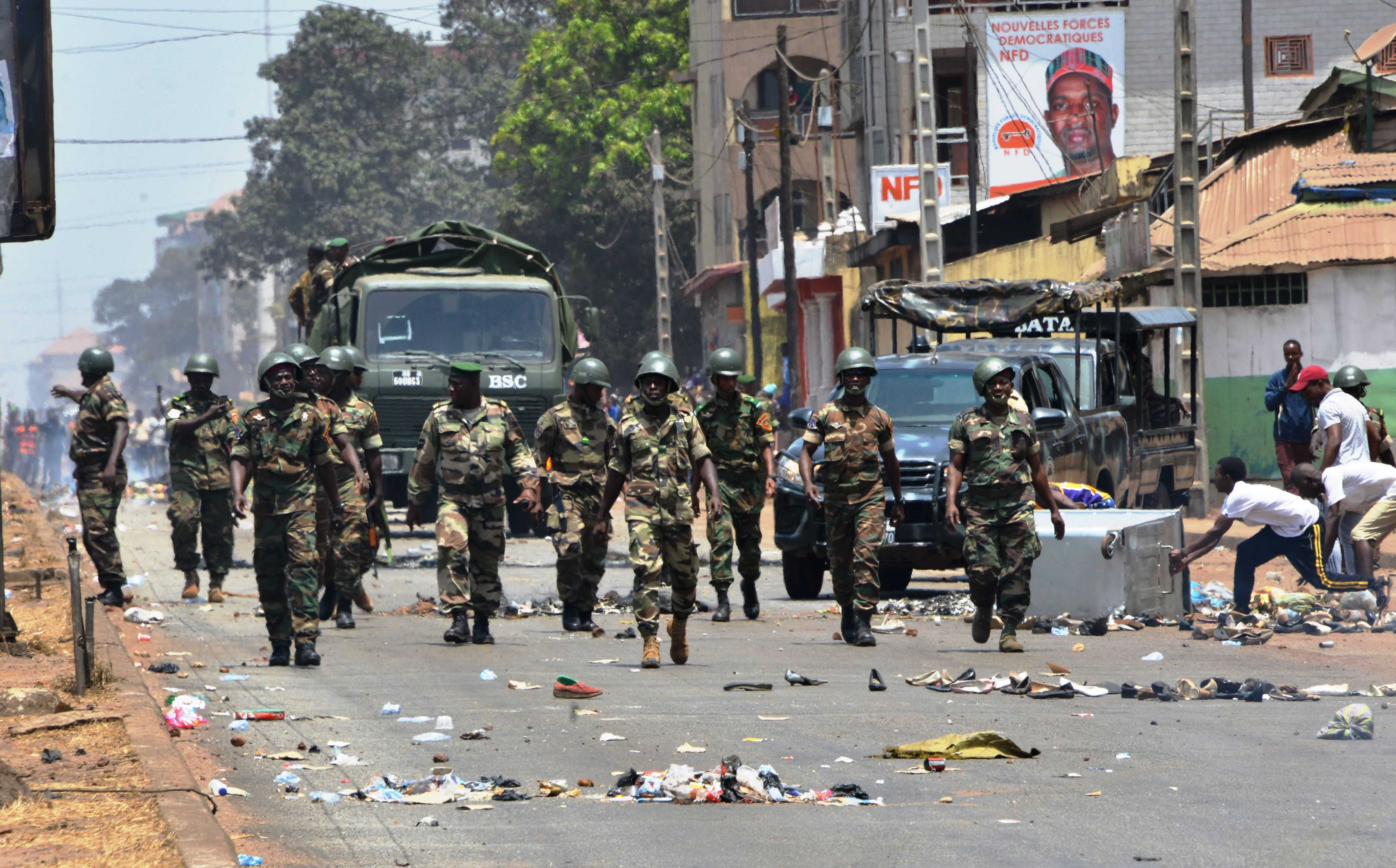 Uniformed soldiers march down a city street 