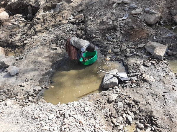 A 9-year old girl collects sand at a mining site in Uganda. 