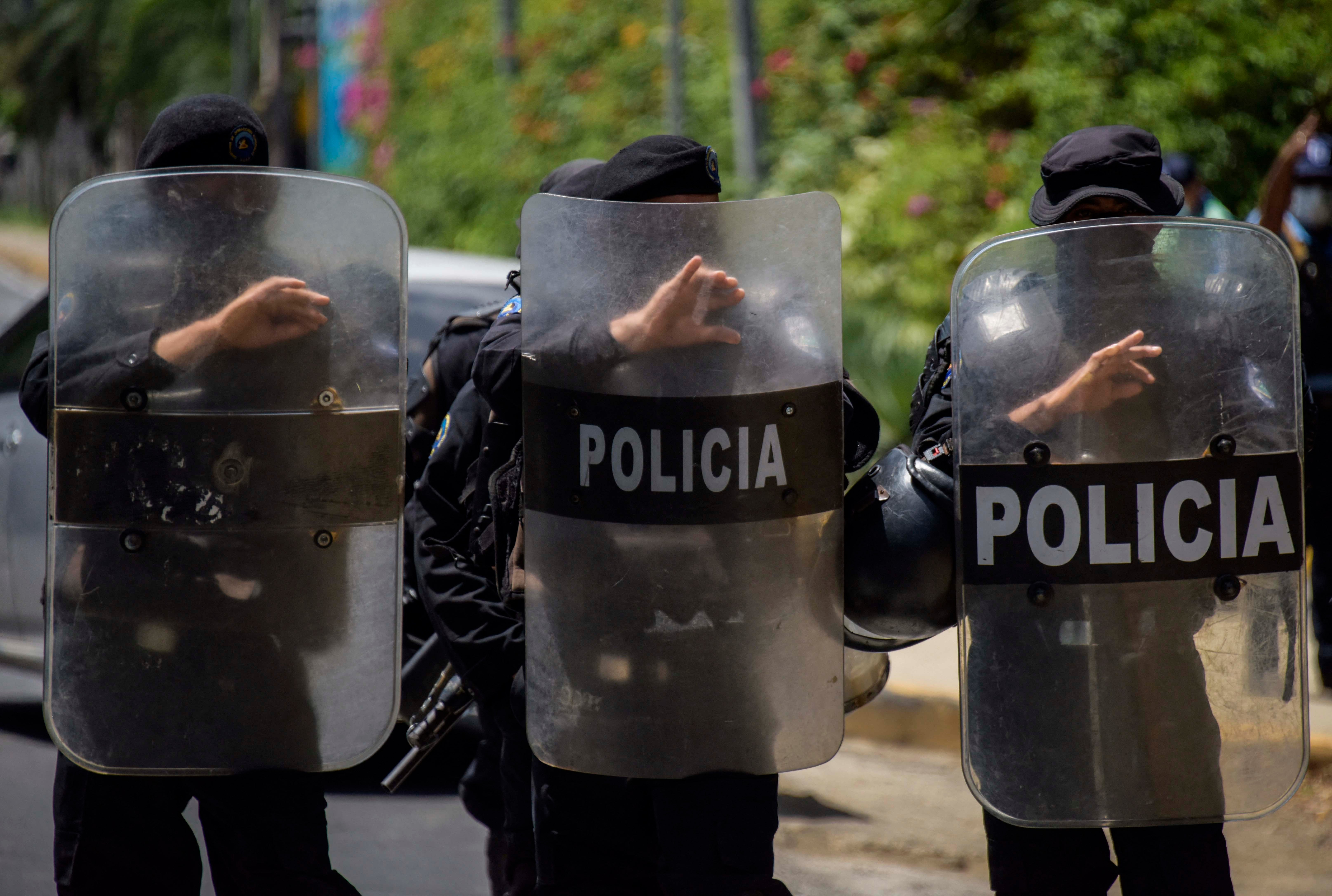 A row of police holding riot shields