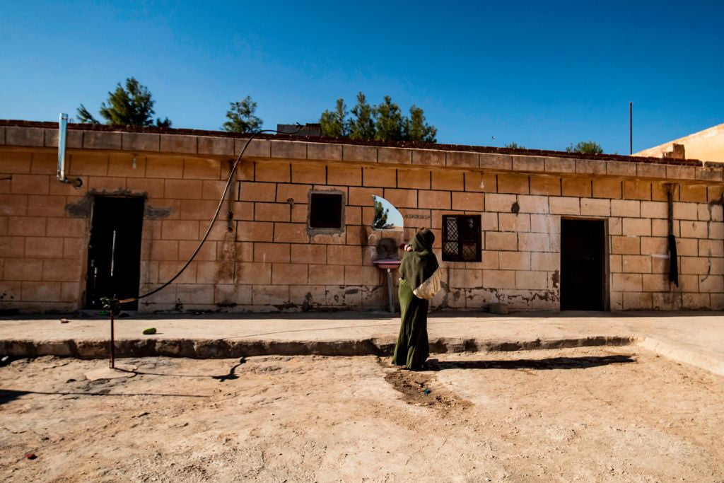 A 22-year-old Iraqi Yezidi woman carries her 2-year-old son at her home in al-Hasakeh, northeastern Syria, on November 23, 2020.