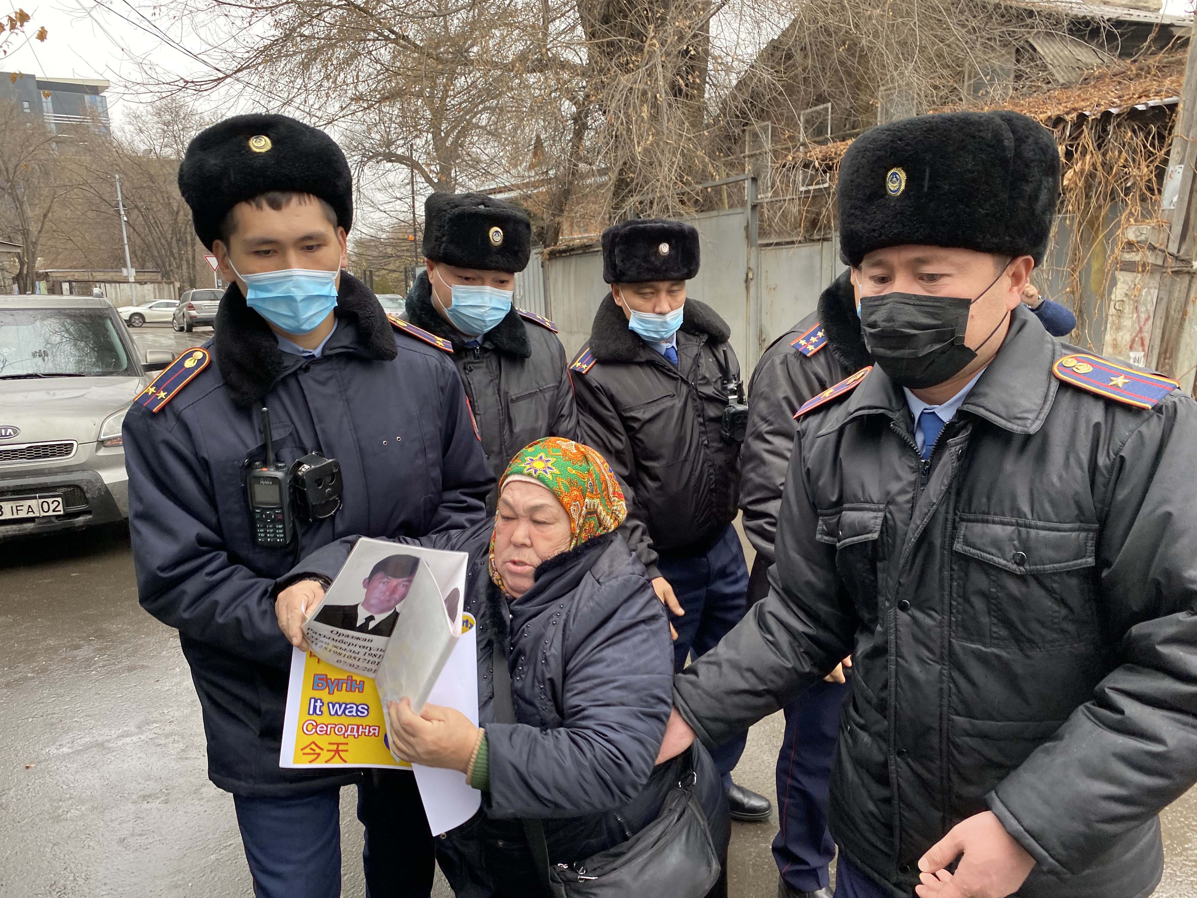 Police detain Khalida Akytkhan outside the Chinese Consulate in Almaty, Kazakhstan, where relatives of people detained or disappeared in Xinjiang, China have been protesting for over 300 days.