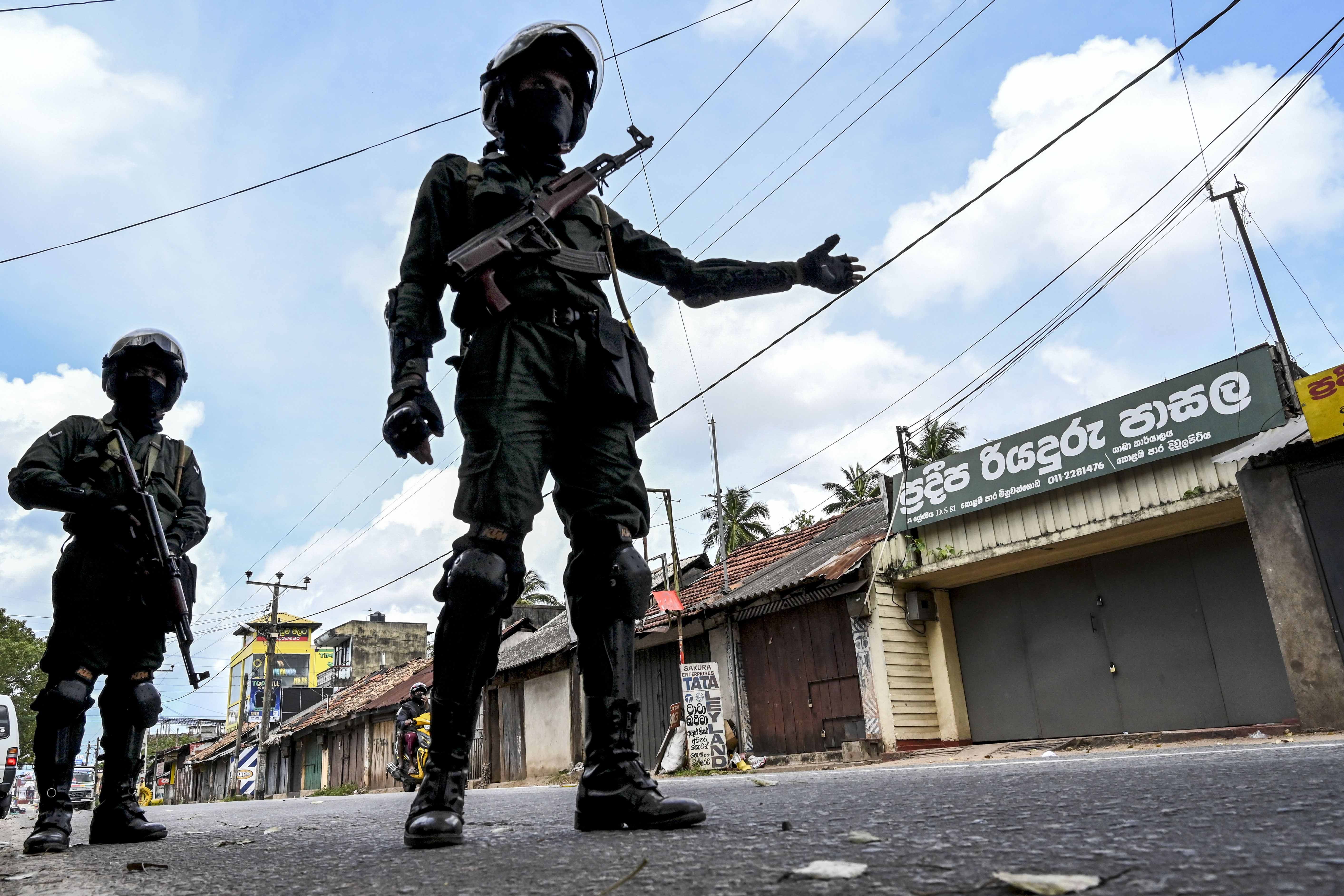 Two uniformed police officers gesture in a road