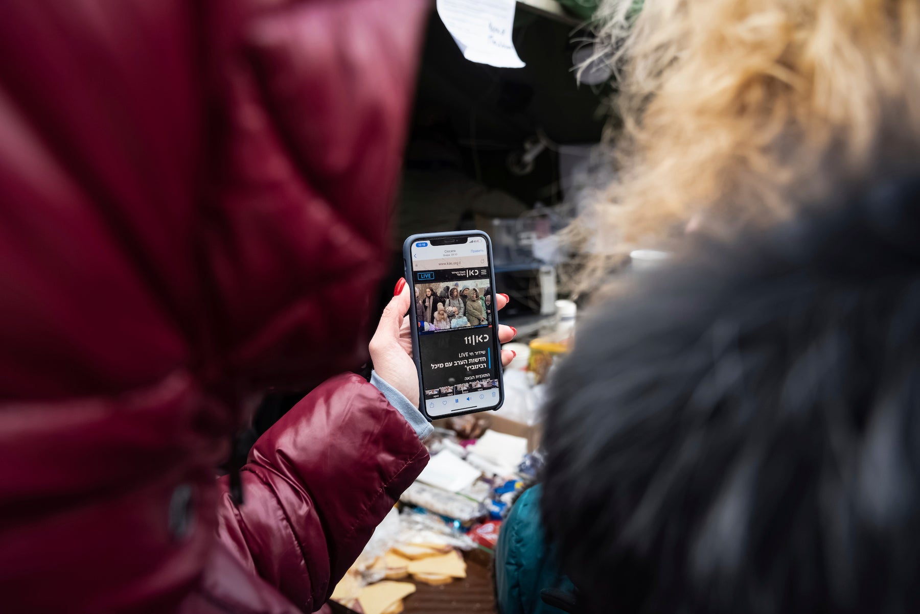 Two women from Kharkiv, Ukraine, watch news on a mobile phone, just after having crossed the border into Moldova, on March 10, 2022.