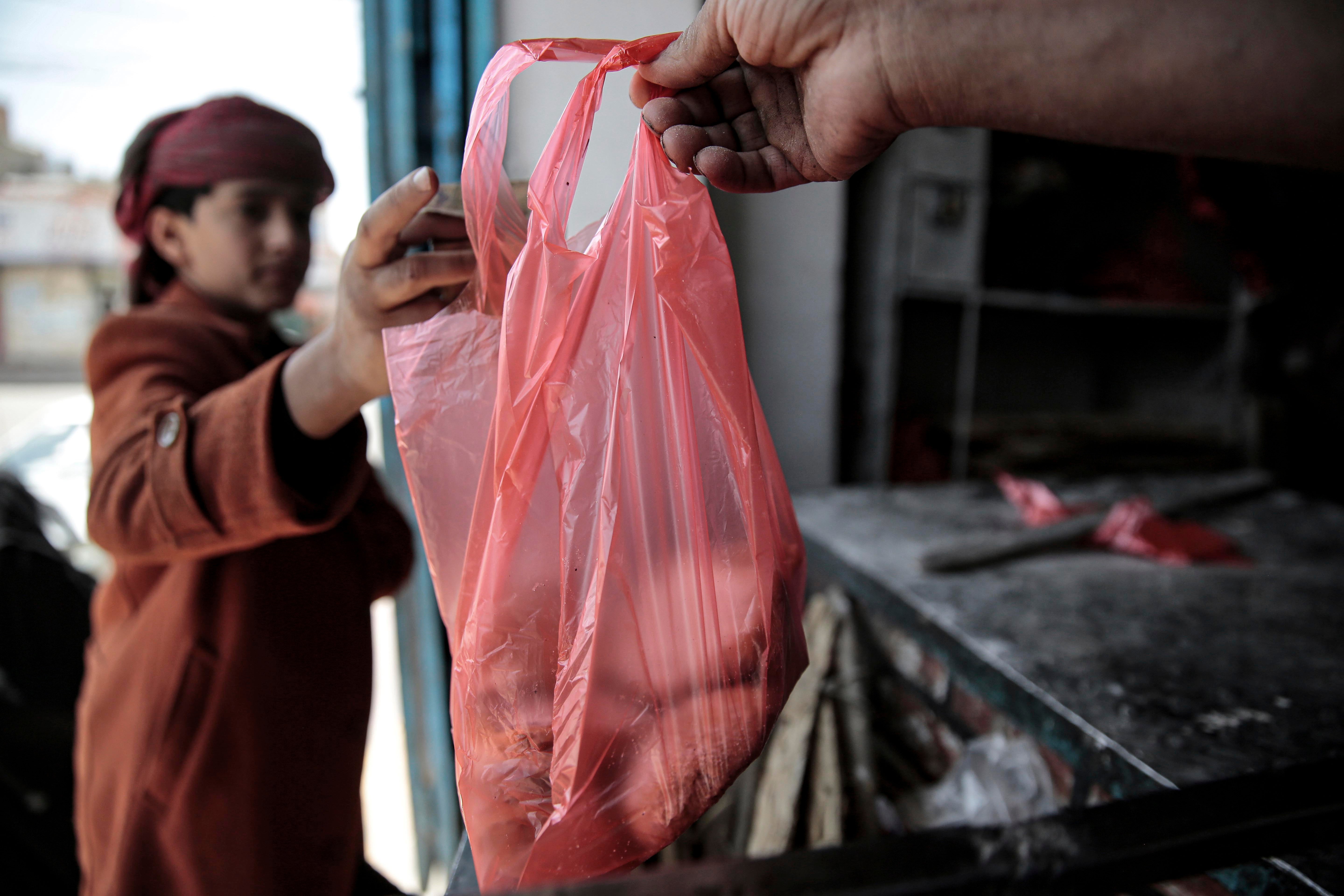 A boy is handed a bag of bread