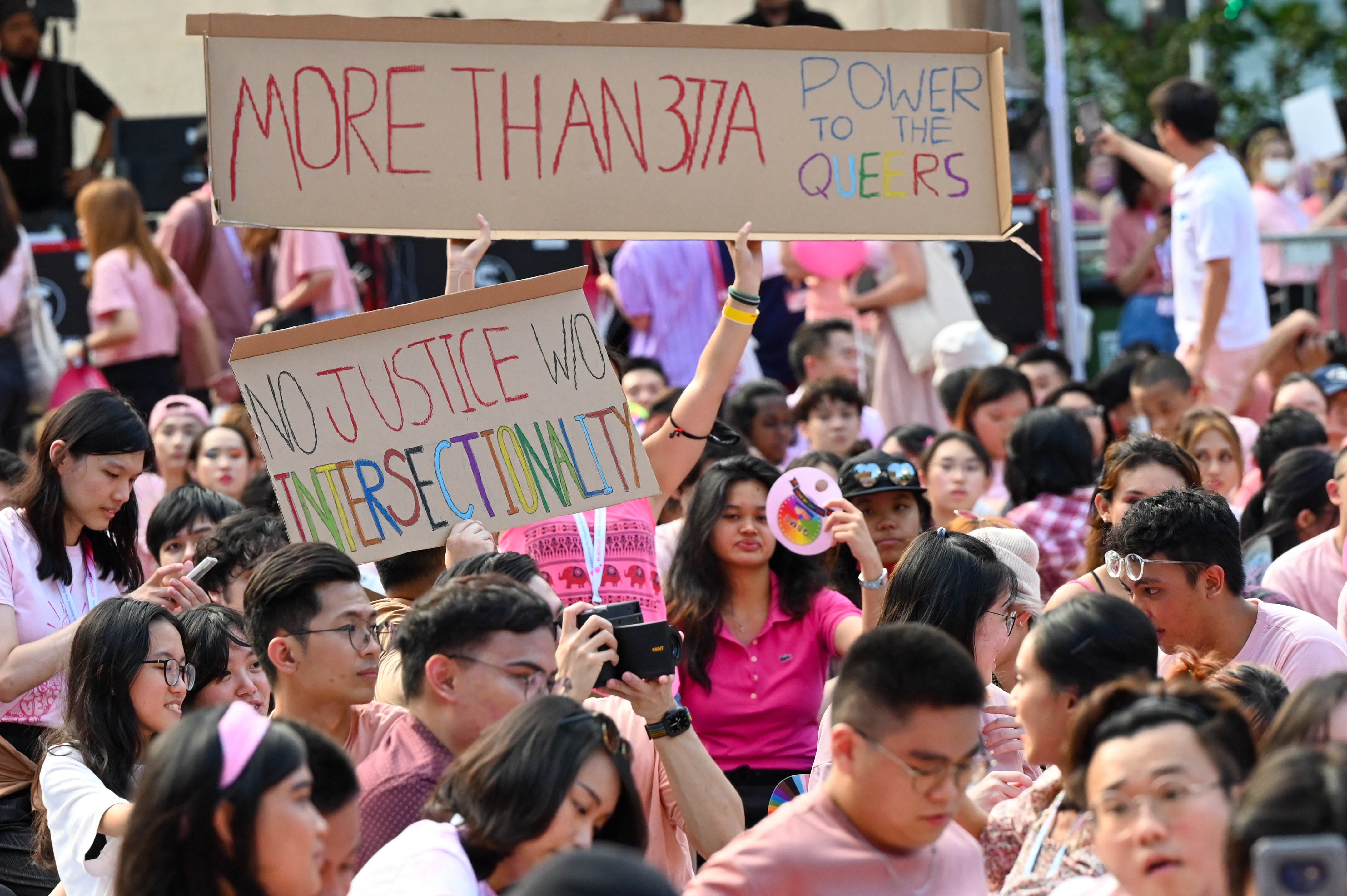 Demonstrators hold pro-LGBT signs at a rally