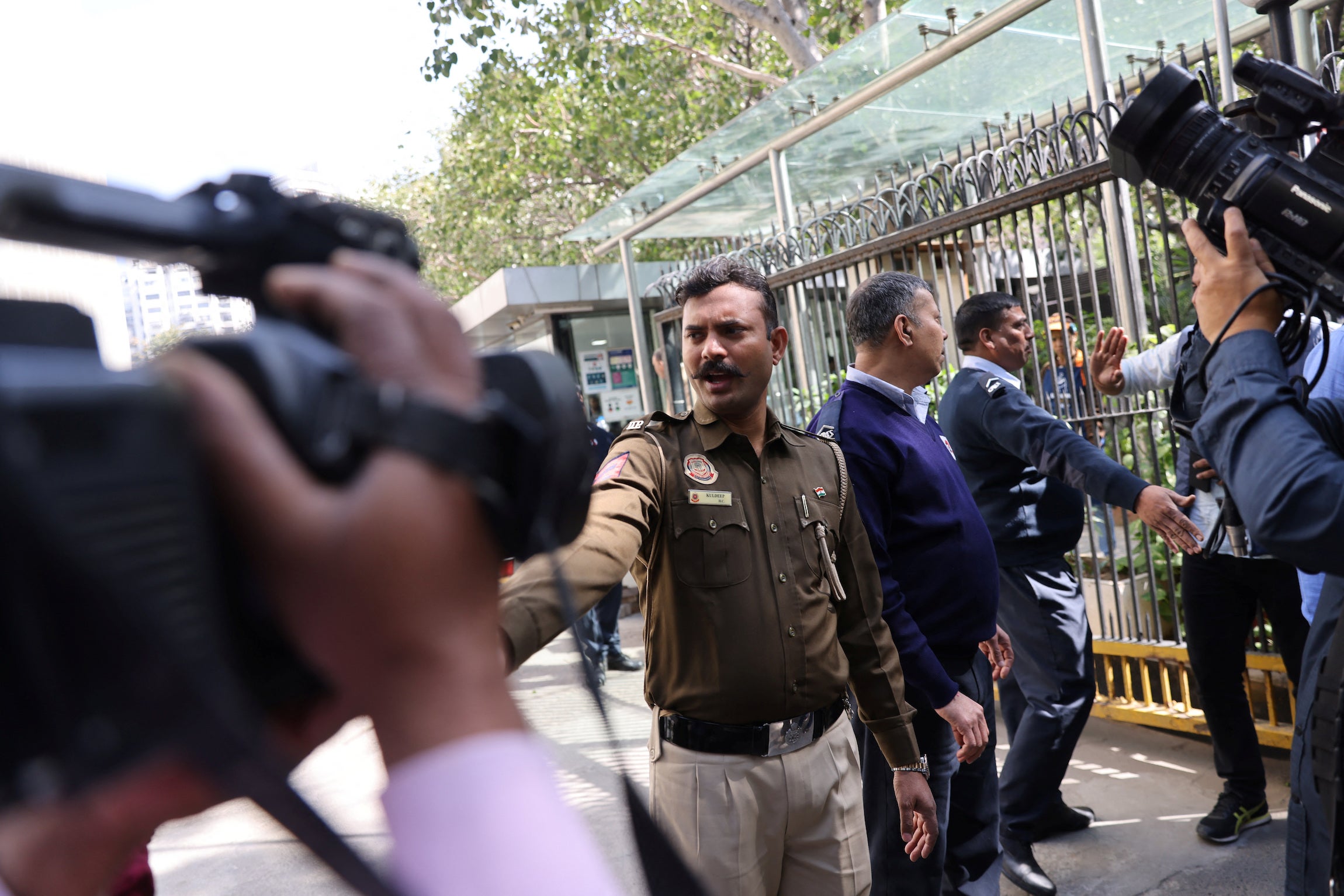 Police officers stand outside a building having BBC offices, where income tax officials are conducting a search, in New Delhi.