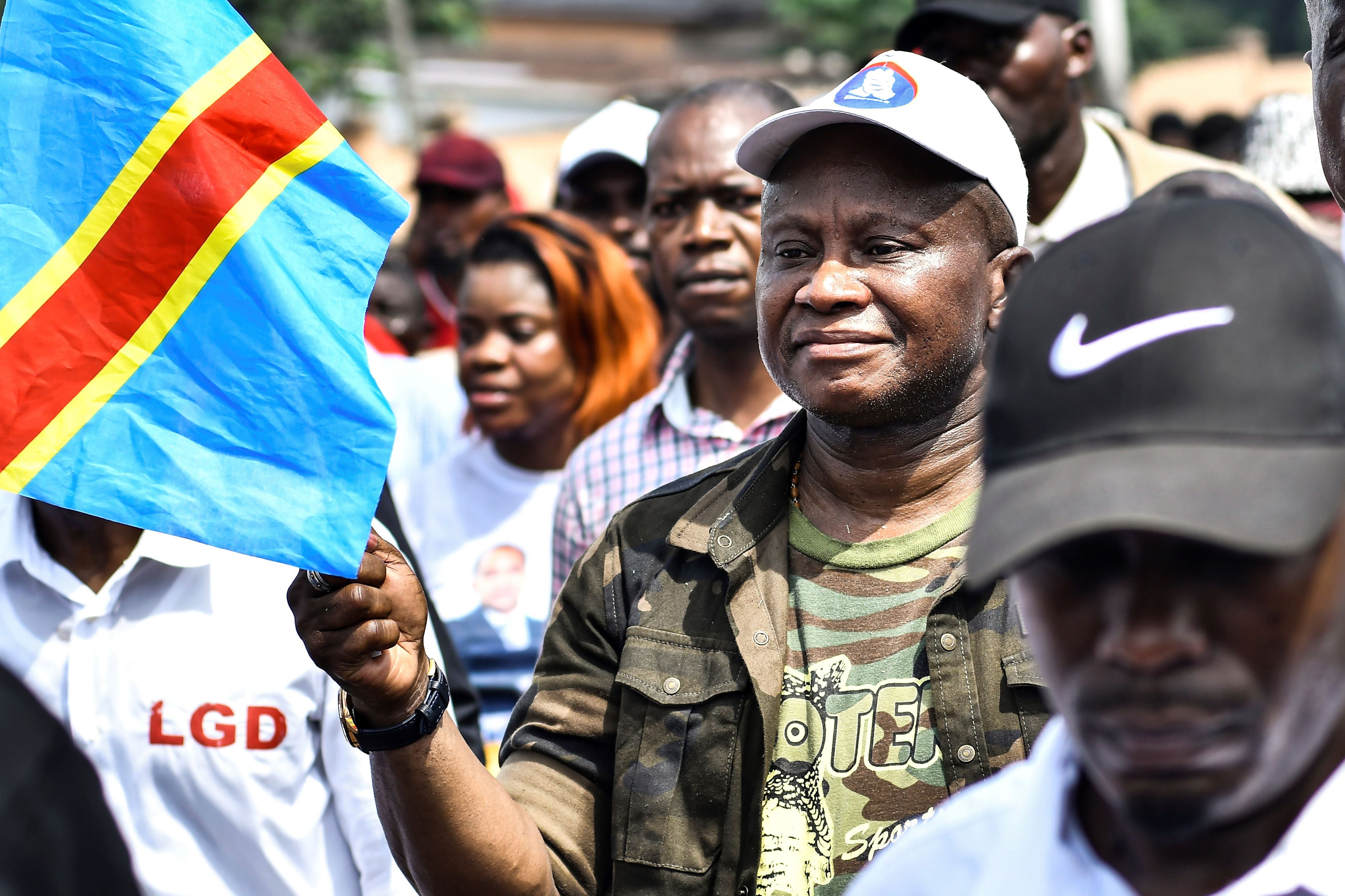 A man holds the flag of Democratic Republic of Congo in a march