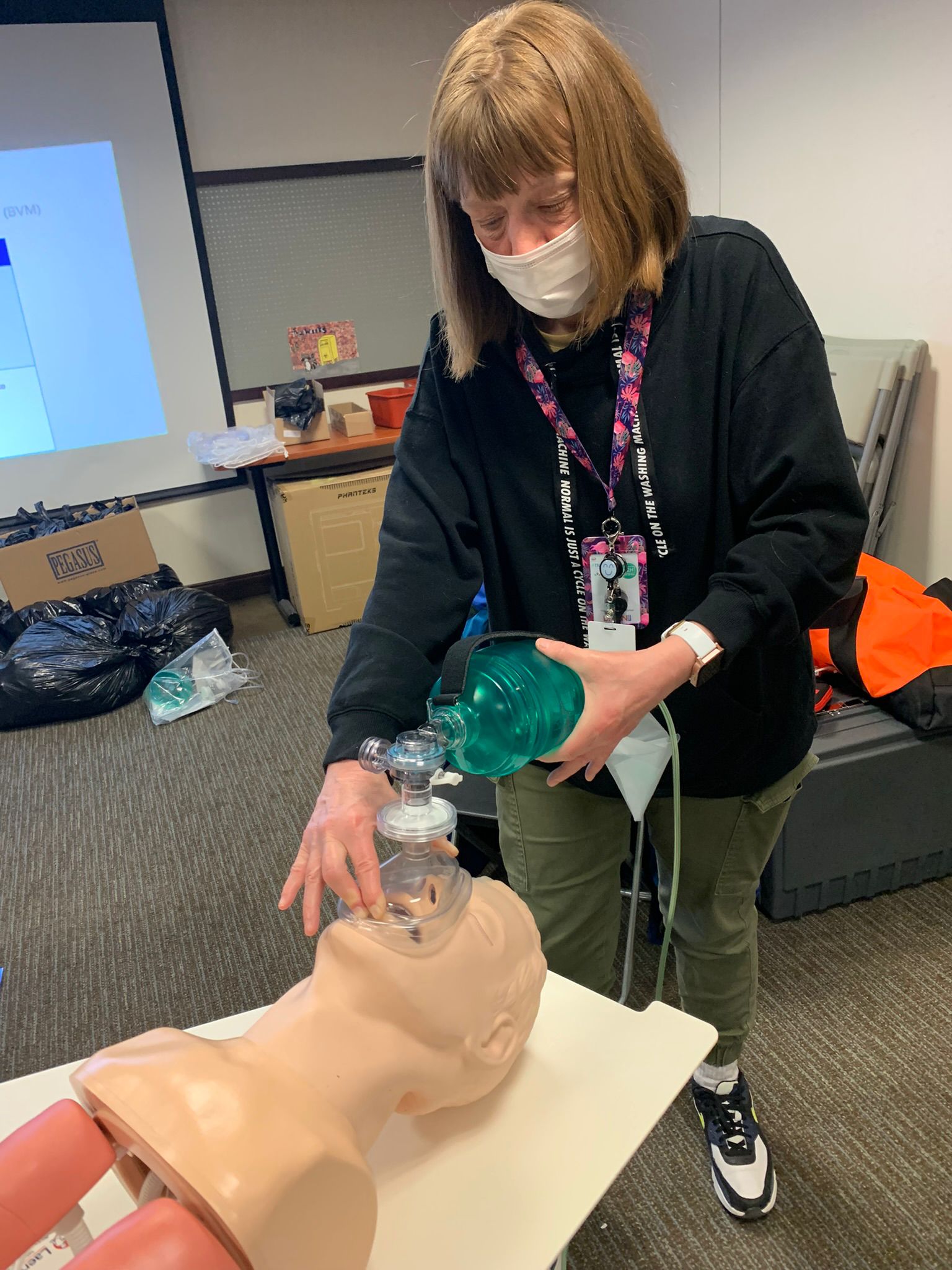 A woman practices first aid on a dummy