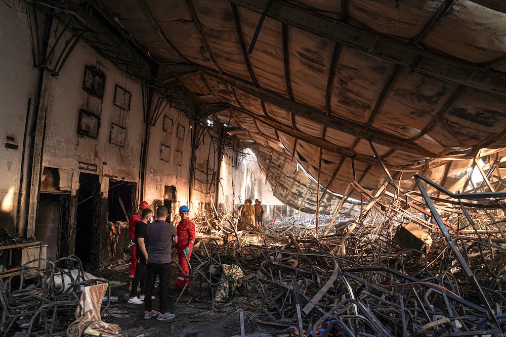 Members of the search team work at a burned down wedding hall after a fatal fire engulfed the hall during a wedding celebration, September 27, 2023. 