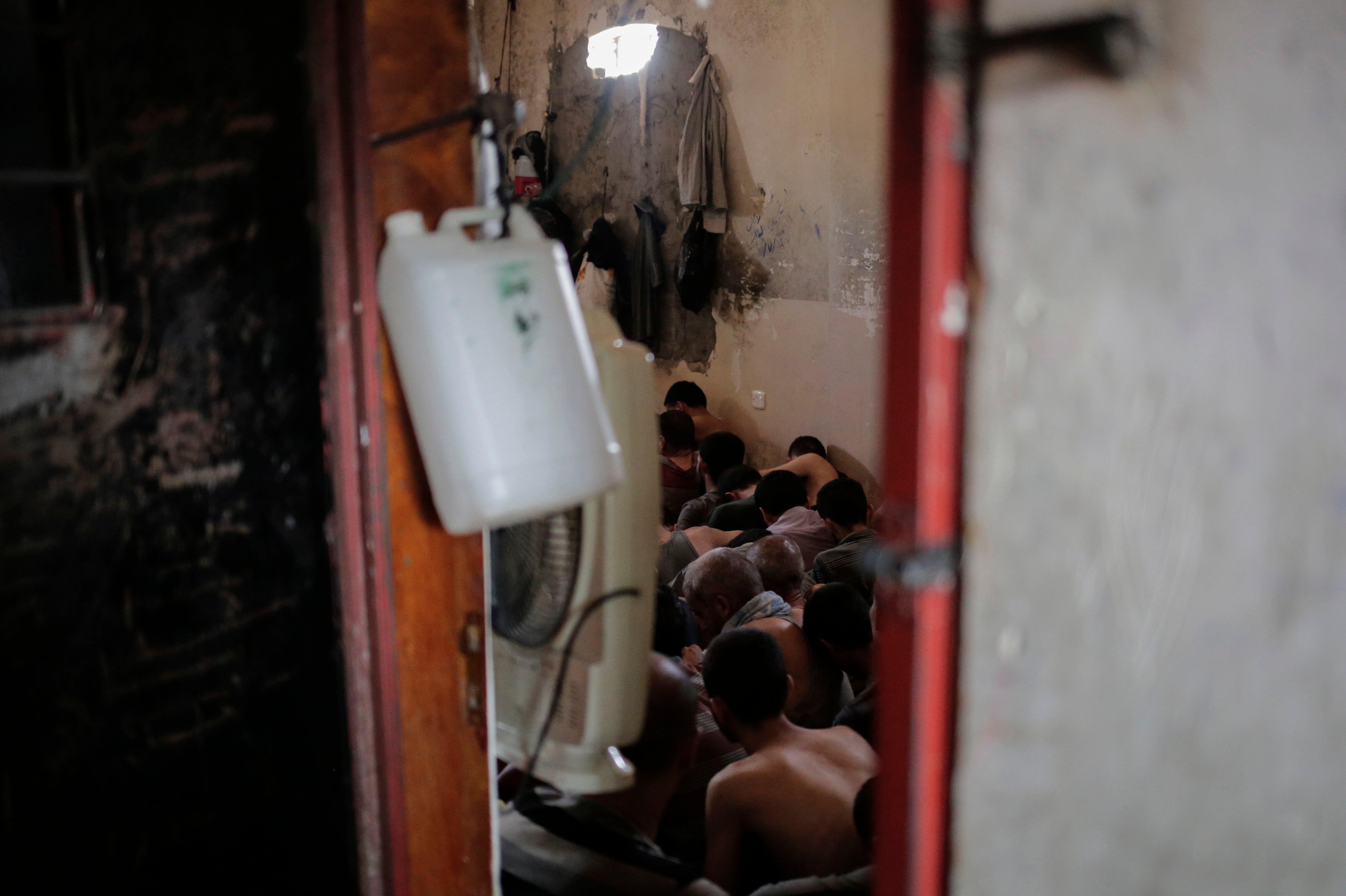 Suspected Islamic State members sit inside a small room in a prison south of Mosul, Iraq, July 18, 2017.