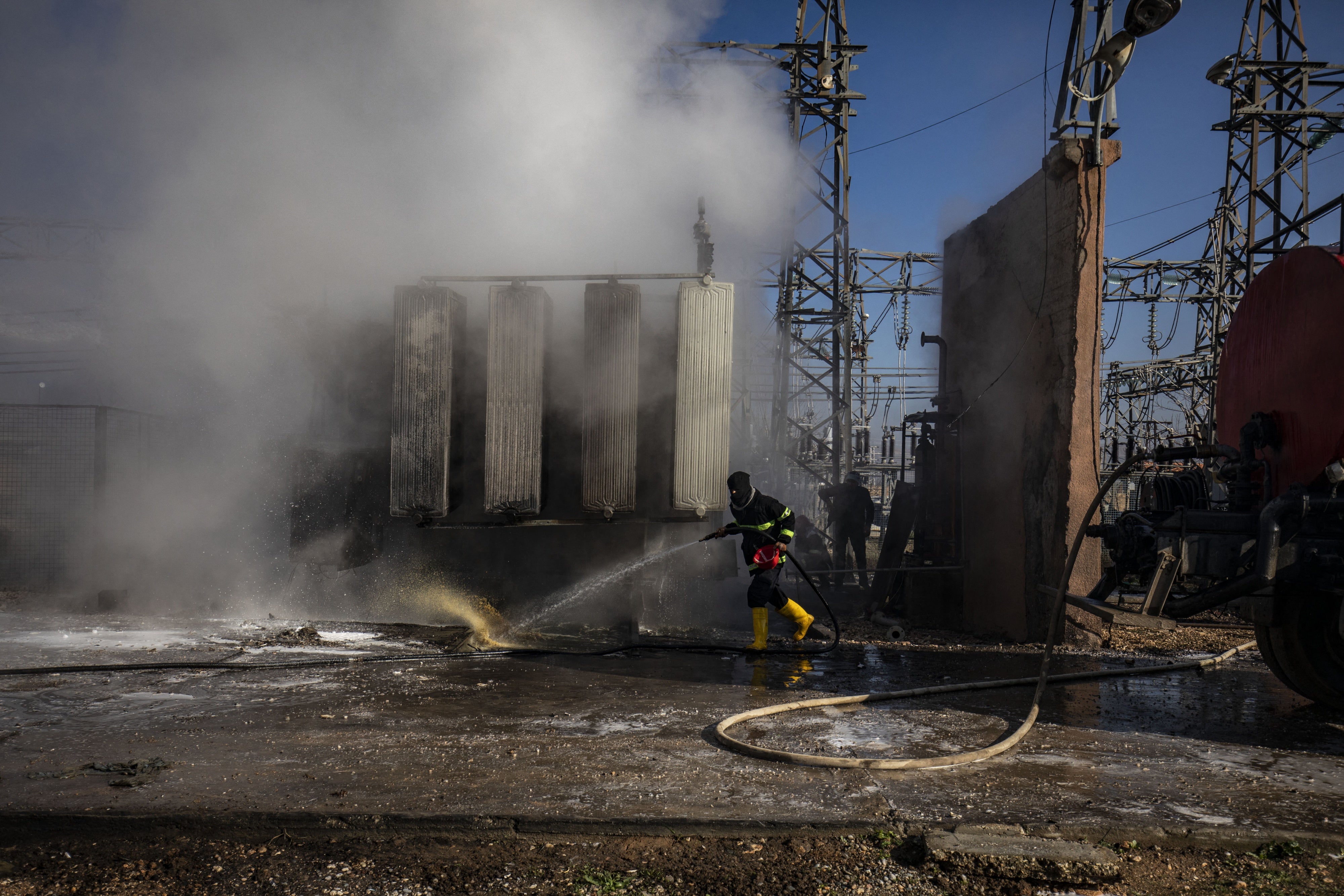 Syrian Kurdish firemen put out a blaze at a power station in Qamishli which was reportedly targeted by Turkish drones on January 15, 2024. 