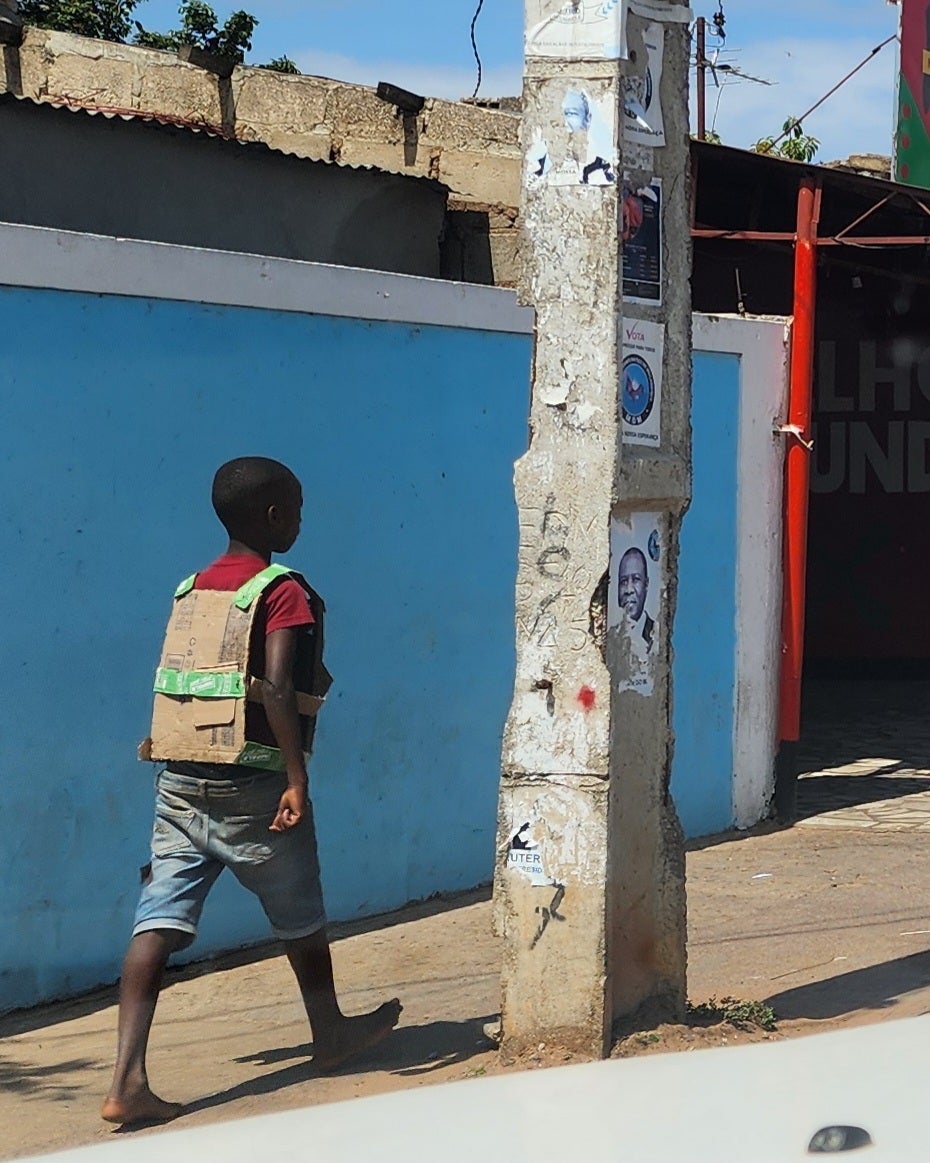 A boy wears a “bullet-proof vest” made of cardboard while walking on the streets of Maputo, Mozambique, November 5, 2024.