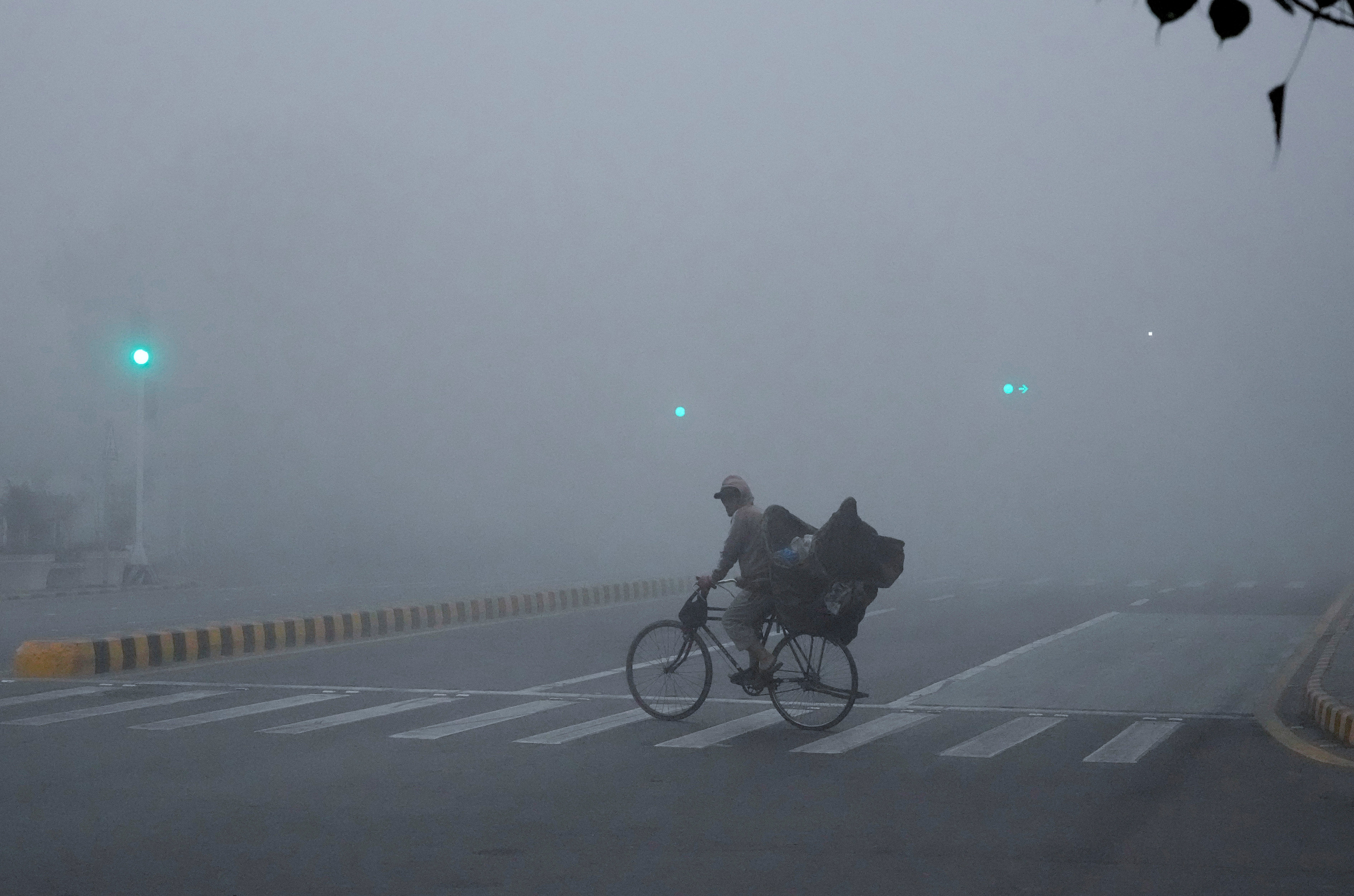 A cyclist crossing a road amid intense smog