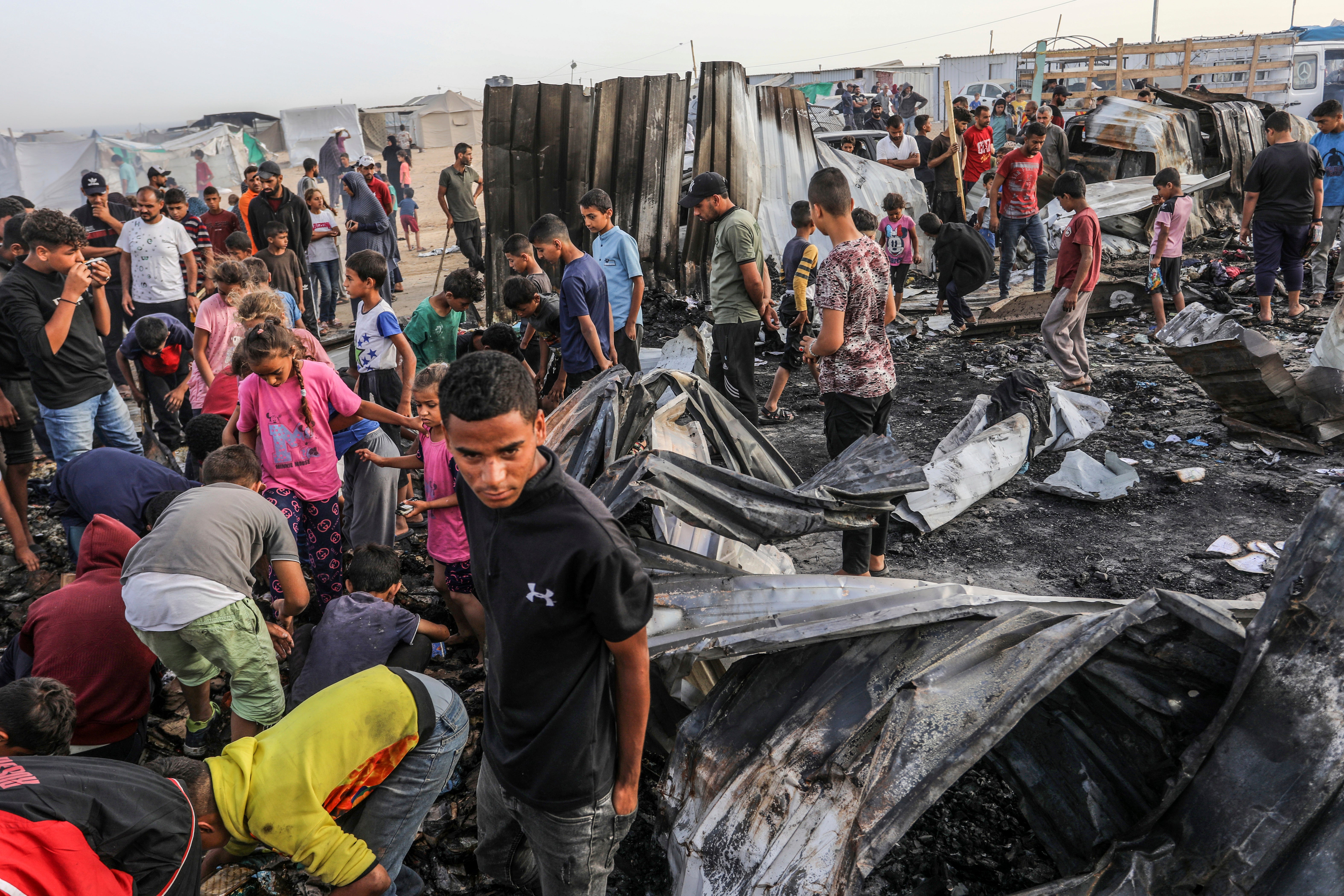 Palestinians inspect their destroyed tents after an Israeli air strike