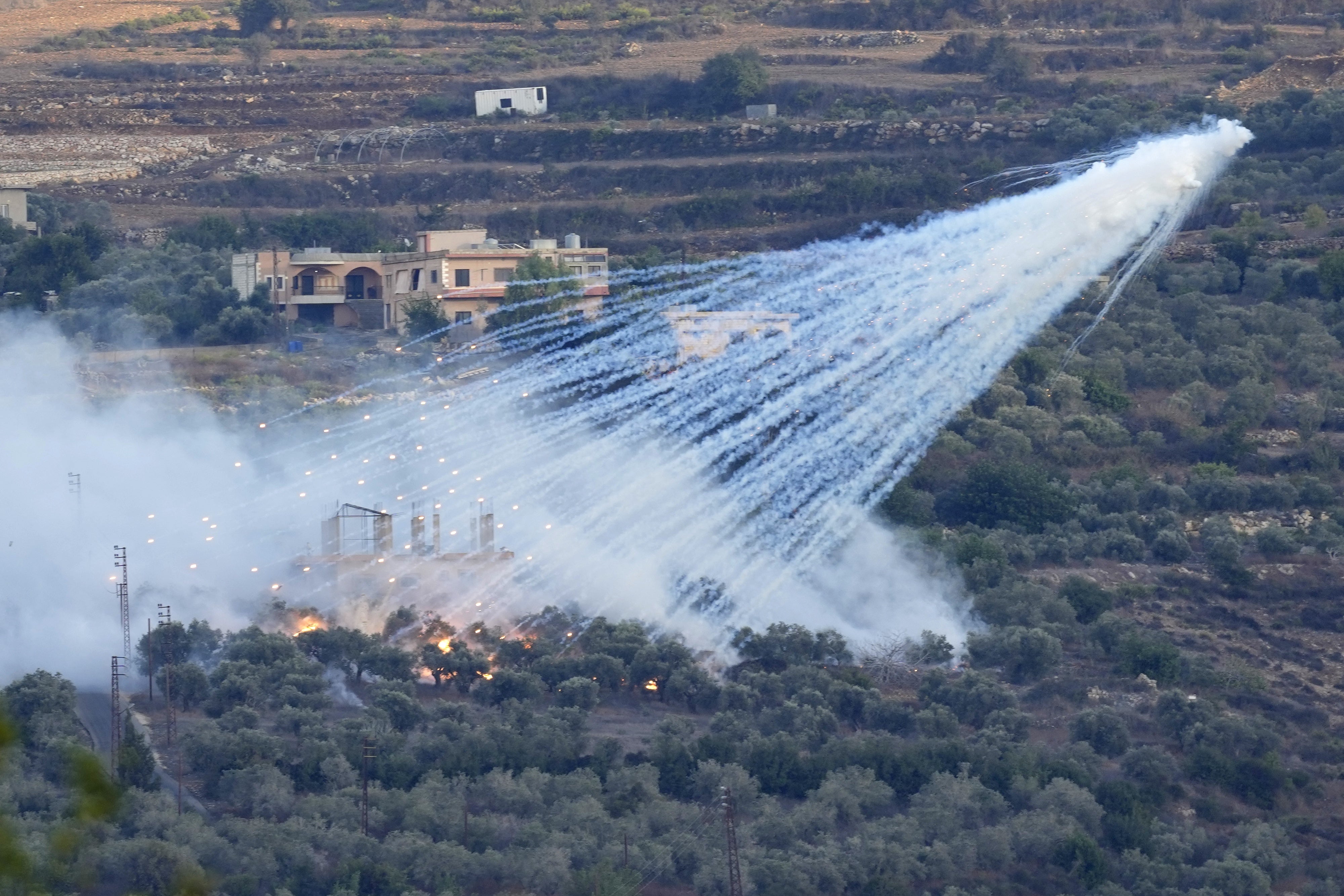 Explosion d’un obus d'artillerie israélien de 155 mm contenant du phosphore blanc et tiré à basse altitude, provoquant des traînées de fumée blanche au-dessus du village d’al-Bustan, un village du Liban dans le sud du Liban, près de la frontière avec Israël, le 15 octobre 2023.