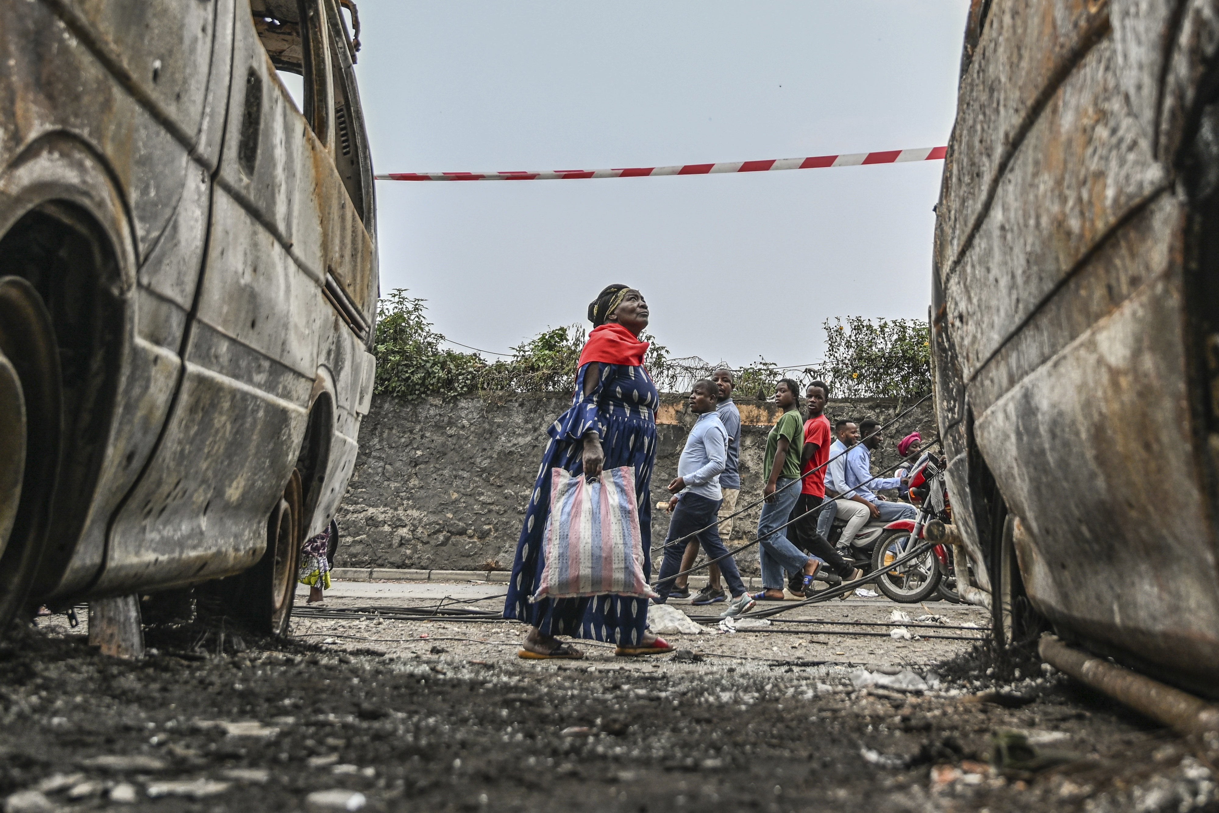 Des habitants marchent entre des véhicules brûlés à Goma, en République démocratique du Congo, le 31 janvier 2025.