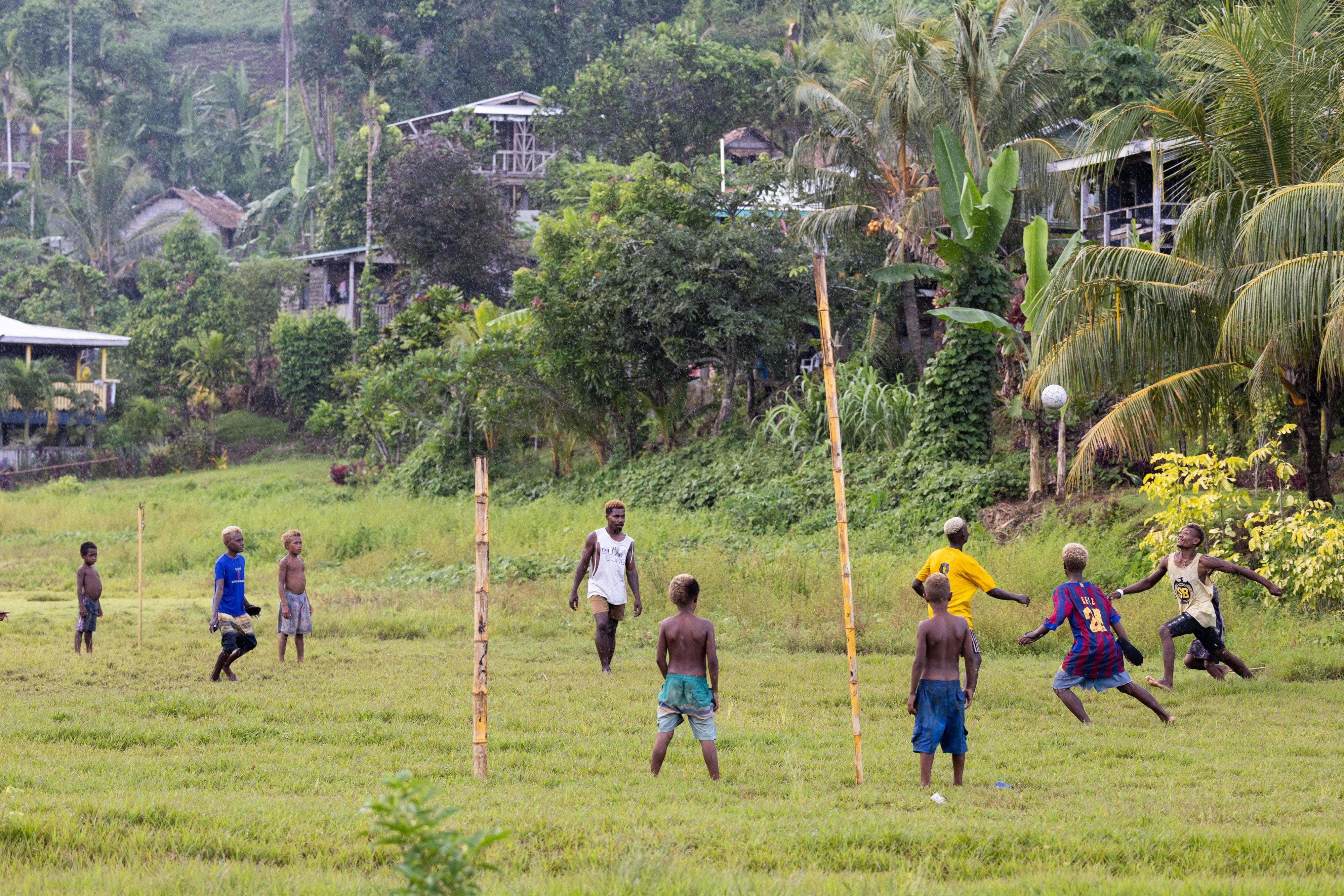 Children playing in the rain in the new site of Walande.