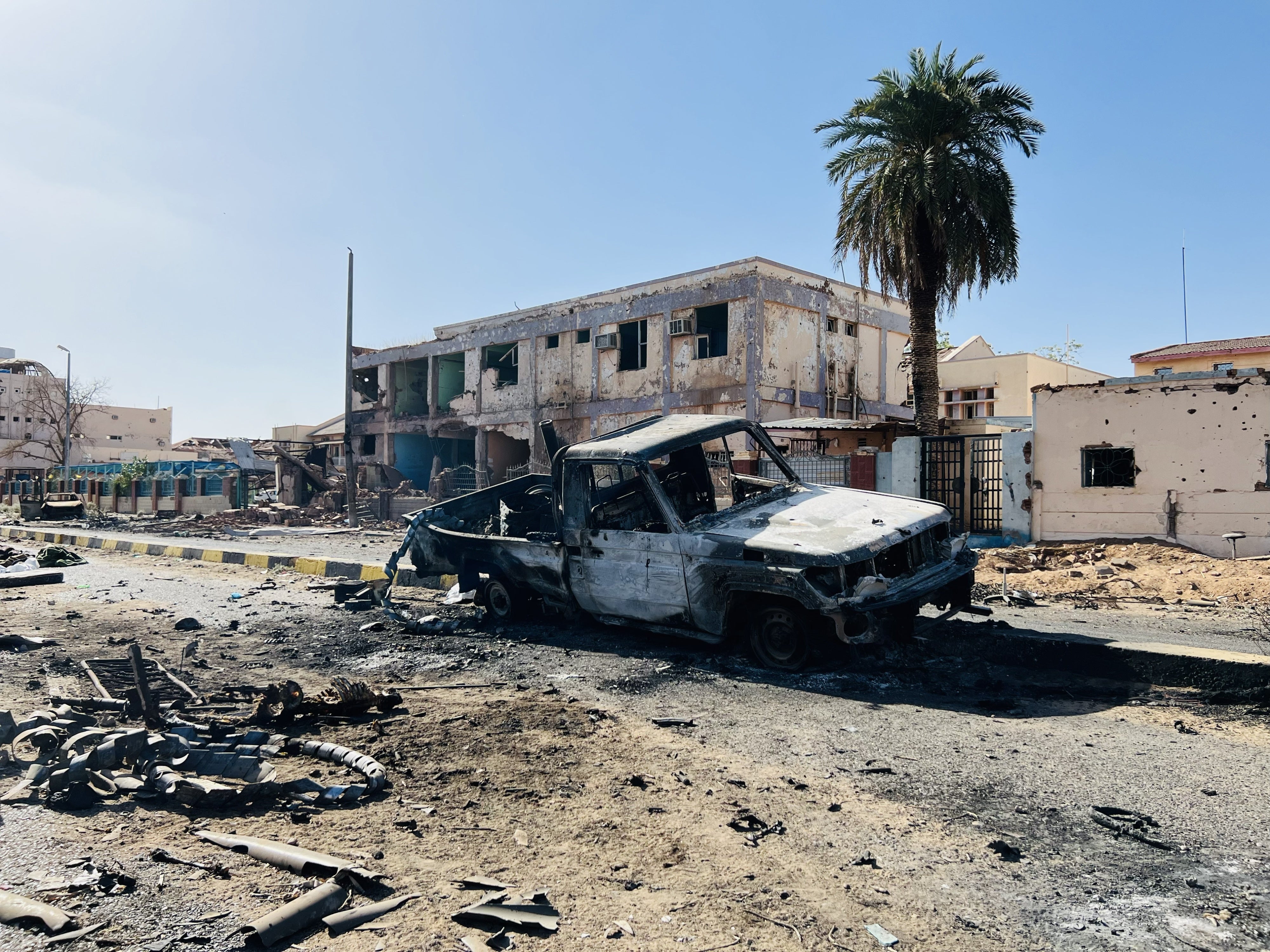 La carcasse d’un véhicule était immobilisée non loin de l'Hôpital universitaire Al-Shaab, partiellement détruit lors de violents affrontements entre les Forces de l’armée soudanaise (FAS) et les Forces de soutien rapide (FSR) à Khartoum, au Soudan, le 29 mars 2025. 