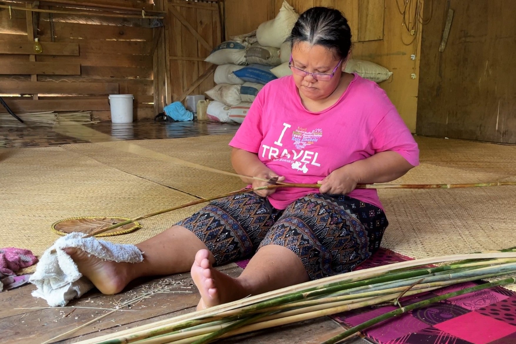 An Iban weaver prepares rattan vines after collecting them in Rumah Jeffery’s forest.