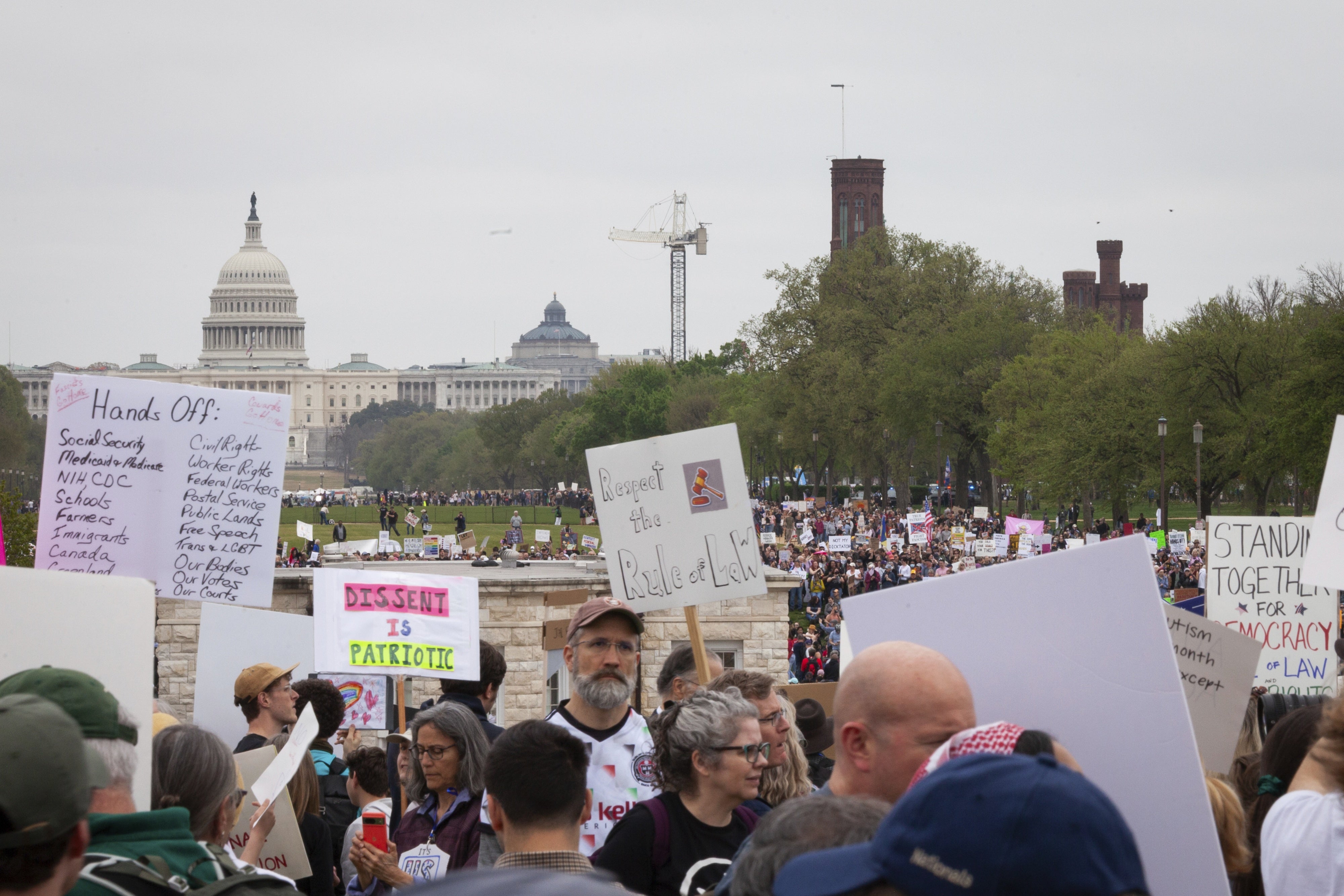 People protest the Trump administration's massive employment and funding cuts in Washington, DC, April 5, 2025.