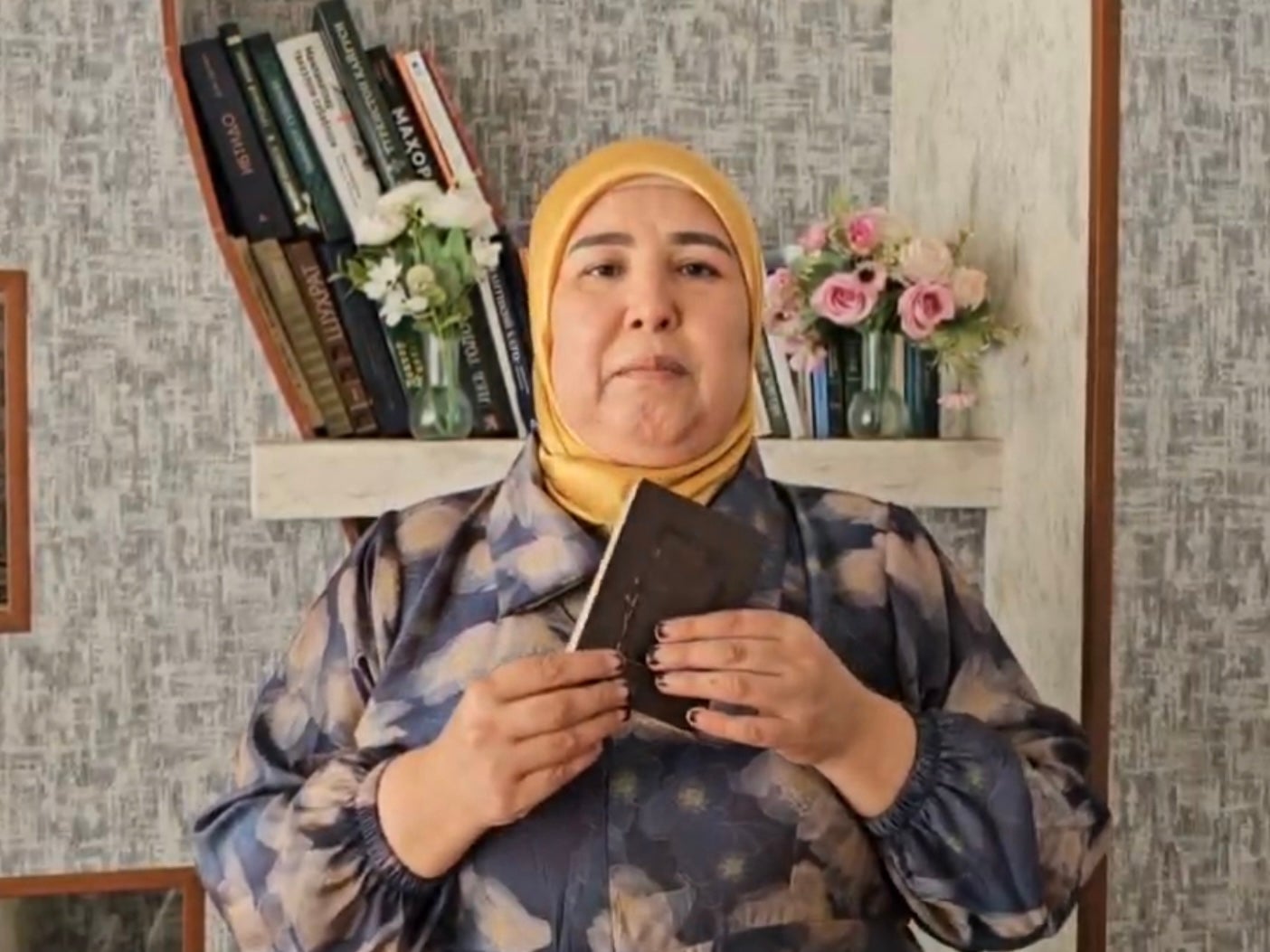 Sharifa Madrakhimova holding her destroyed passport in Uzbekistan, May 2025.