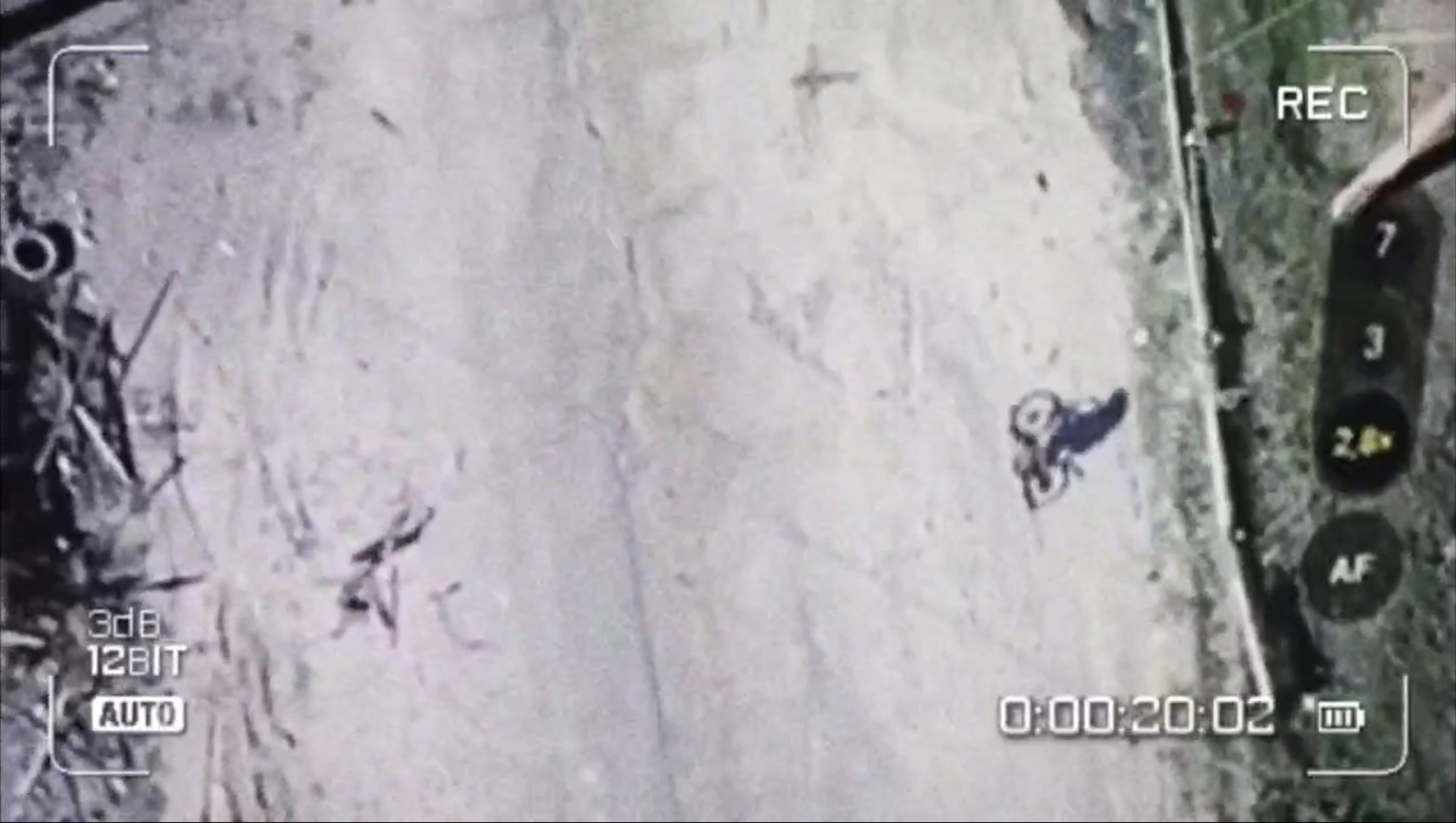 Screengrab of a drone video showing a woman on a bicycle