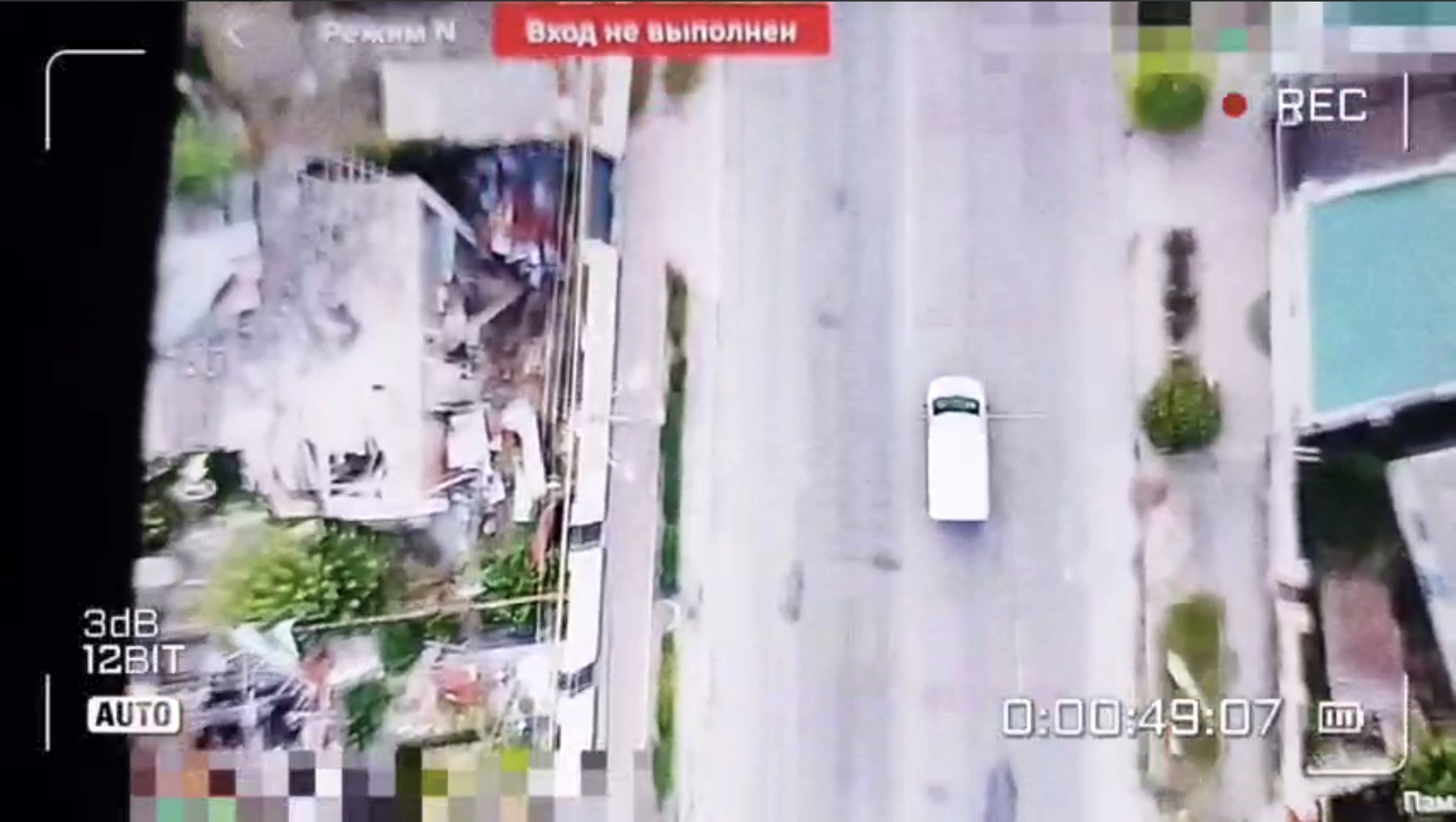 Screengrab of a drone video showing a white van driving down a road