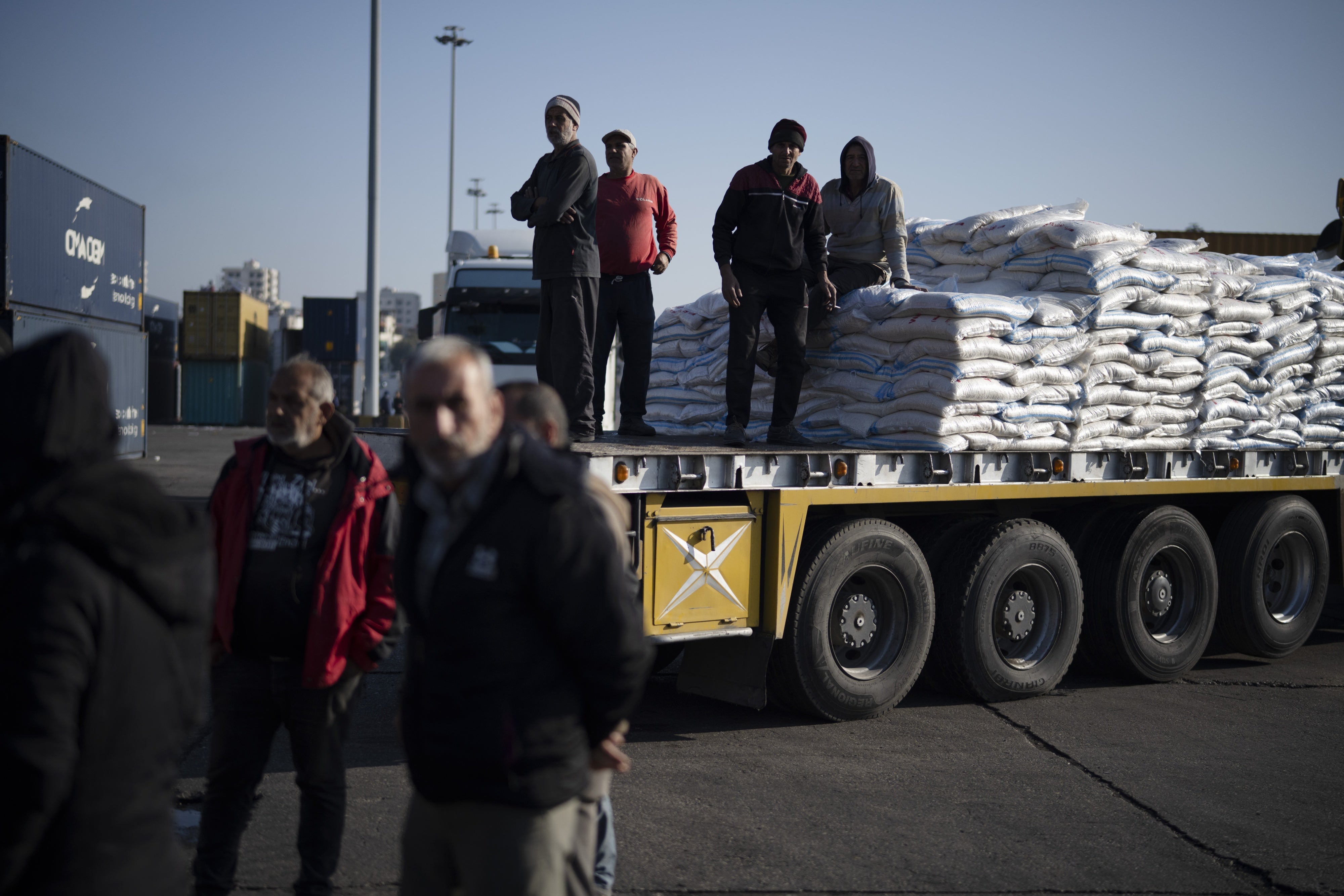 Syrian port workers move on a truck carrying goods at the port of Latakia, Syria, December 17, 2024. 