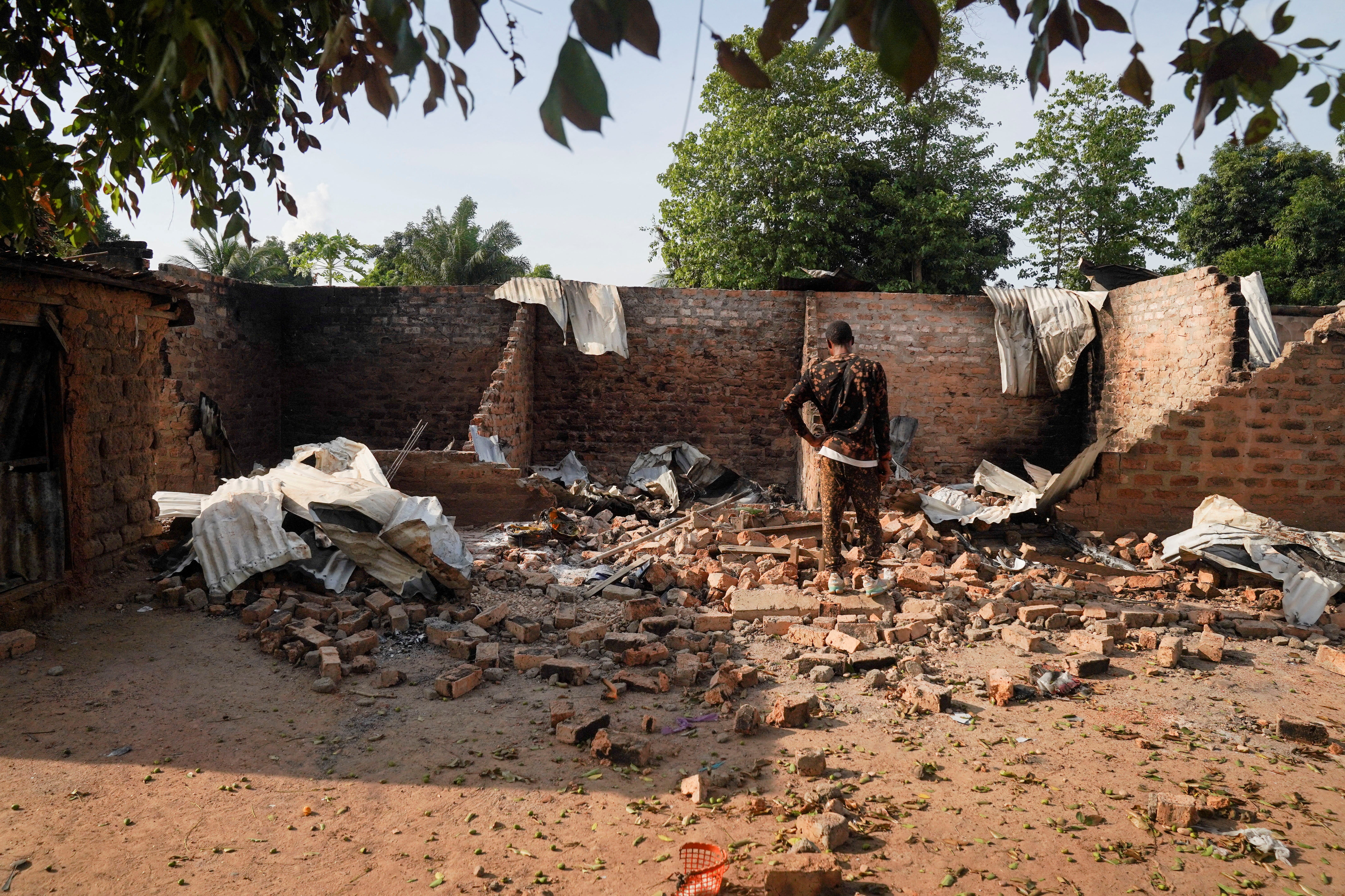 A man stands in front of a damaged and burnt house following a deadly gunmen attack in Yelwata, Benue State, Nigeria, June 16, 2025.