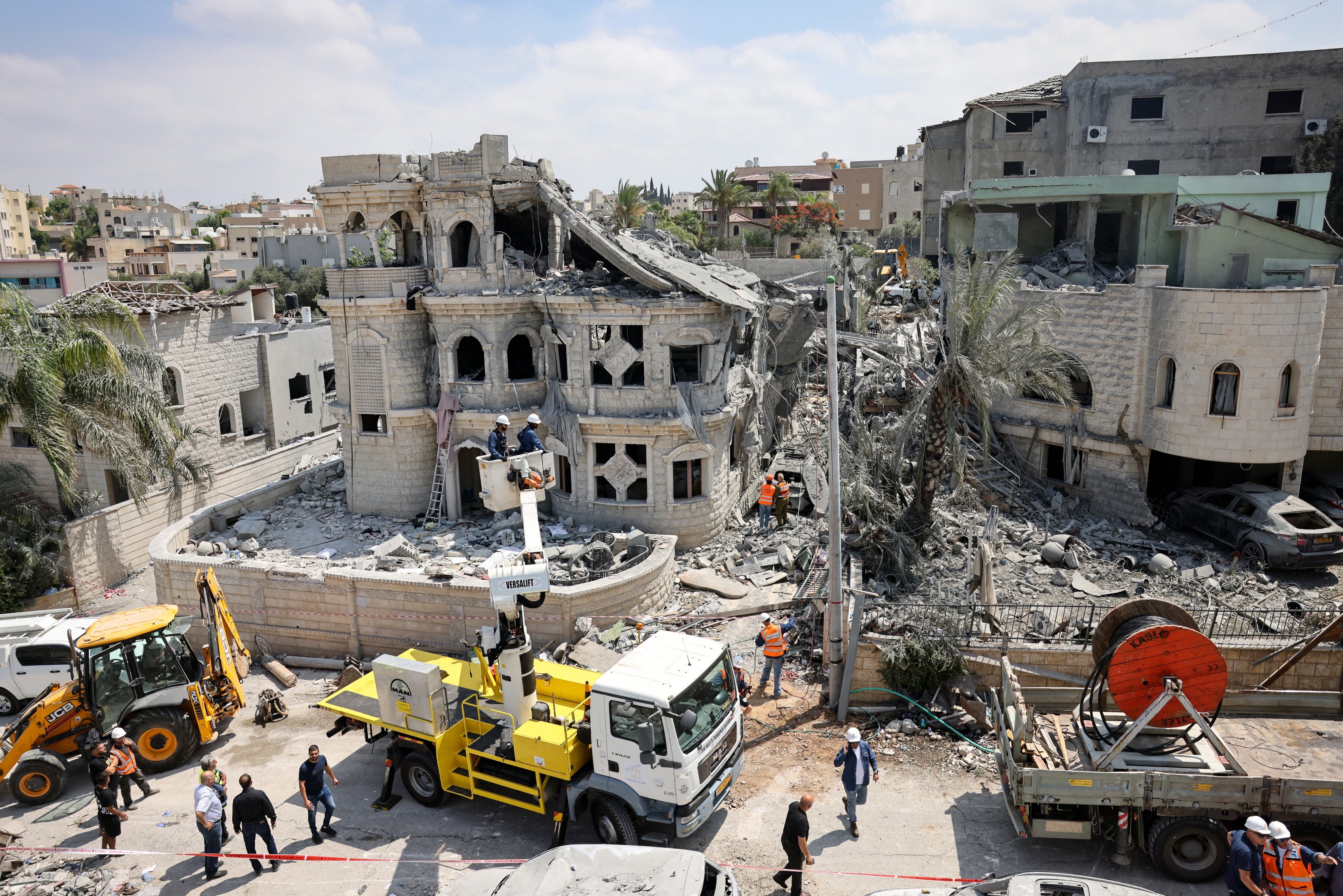 Rescue teams clear rubble at the home of the Khatib family, four members of which were killed in an overnight Iranian missile attack on the Palestinian city of Tamra, in northern Israel on June 14, 2025.