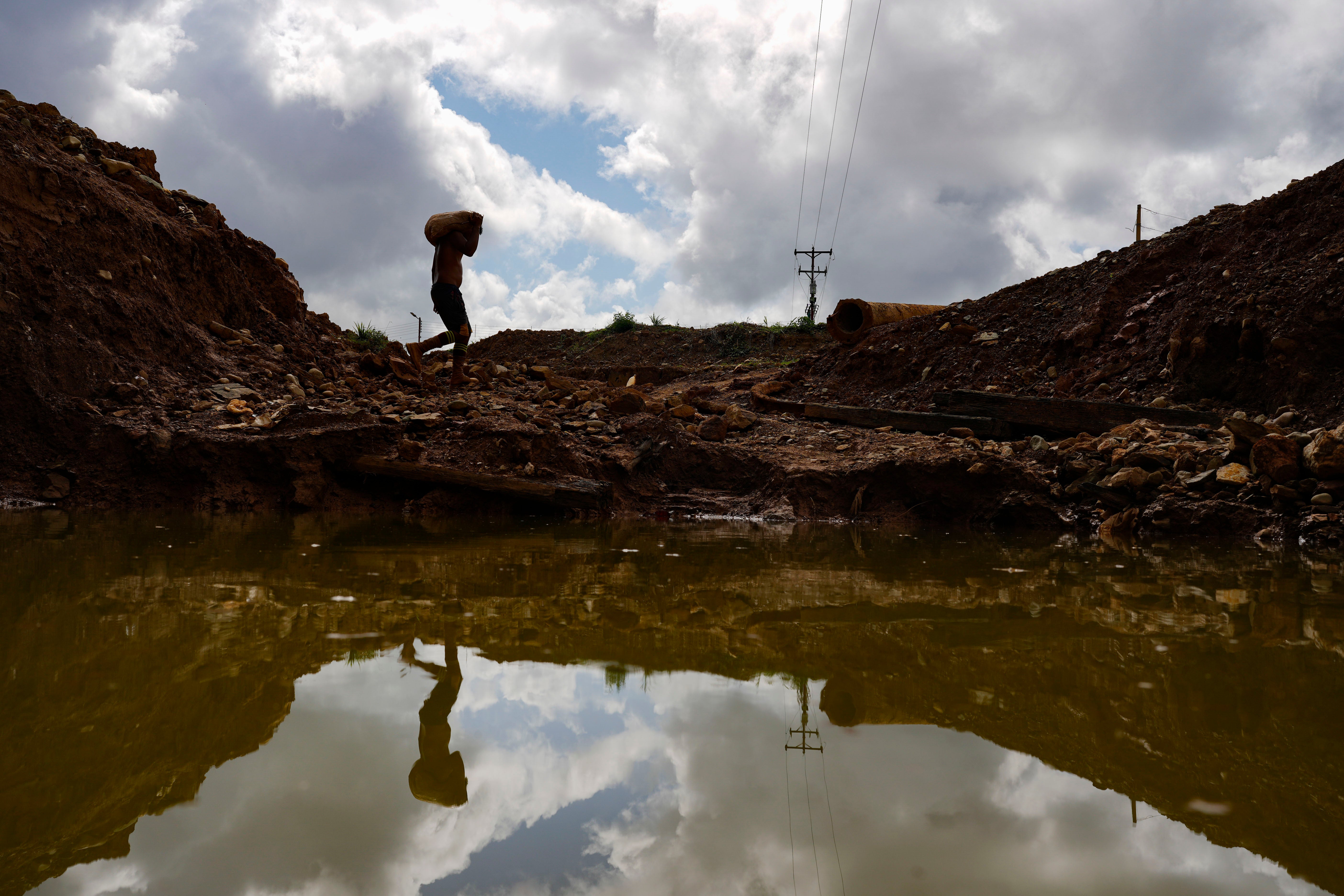 A gold miner carries a sack of rocks to a grinding mill at a mine in El Callao, Bolivar state, Venezuela, April 29, 2023. 