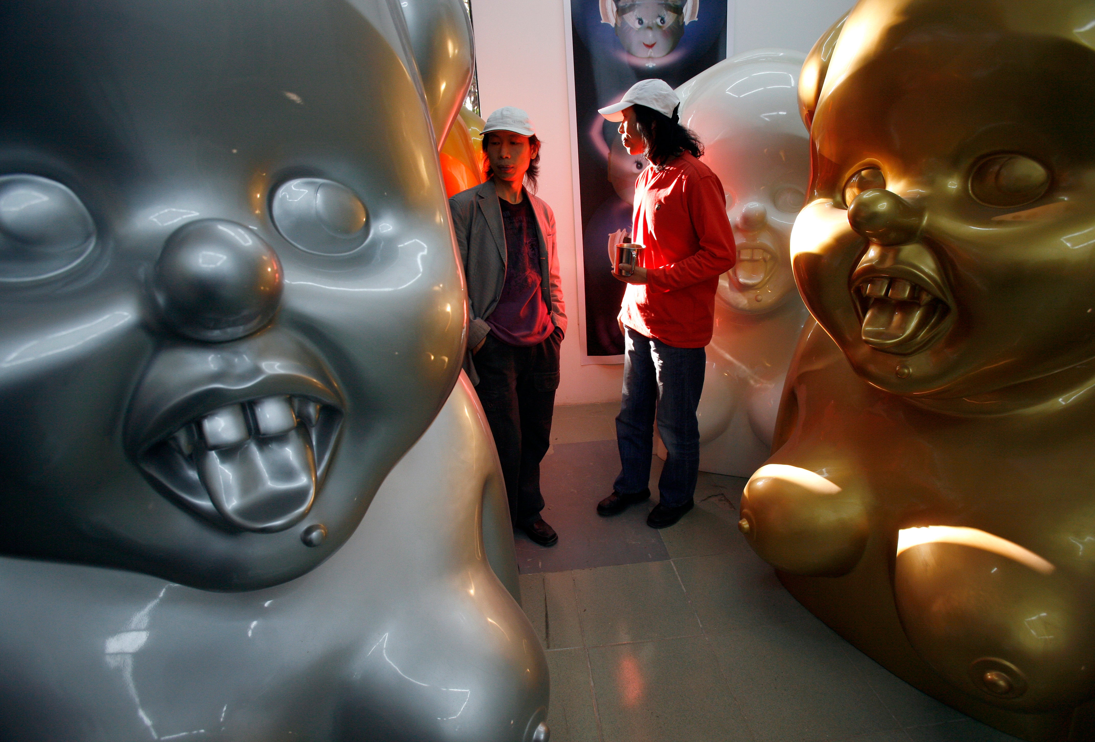 Chinese artists the Gao Brothers, Zhen and Qiang, with some of their "Miss Mao" pieces that feature life-sized, Pinocchio-nosed sculptures of Mao Zedong in their studio in Beijing, October 16, 2007.