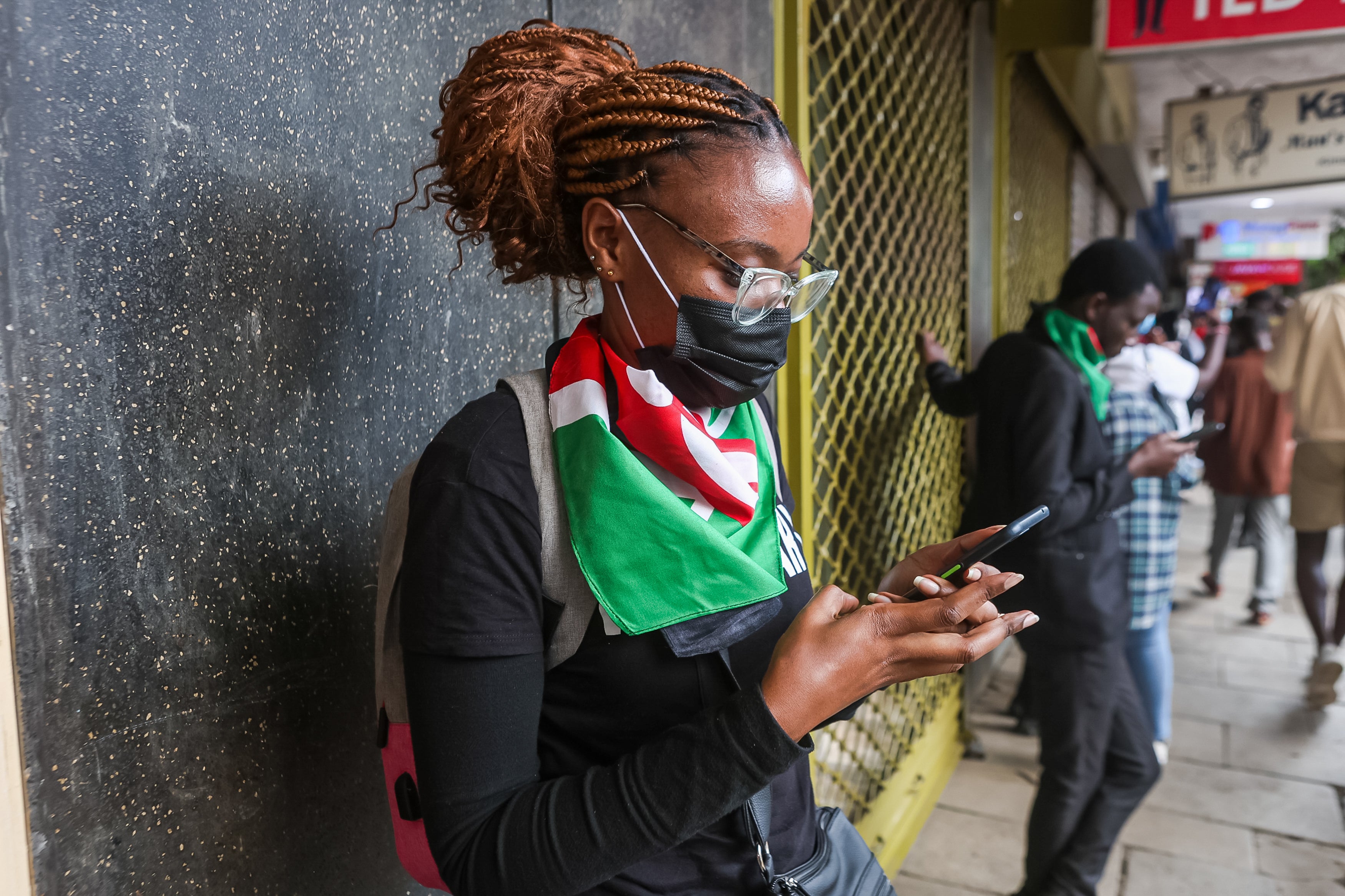 A protestor checks her phone during the youth-led protests against proposed tax hikes in Kenya's finance bill 2024/2025.
