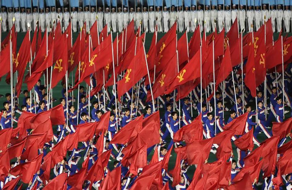 North Koreans hold Workers' Party flags during a mass performance in Pyongyang on July 26, 2013. 