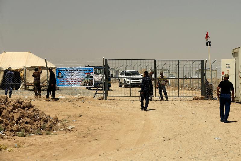 Iraqi Security Forces stand guard at the gate of a camp holding families of men suspected of being ISIS affiliates in Bartalla, east of Mosul, Iraq July 15, 2017.