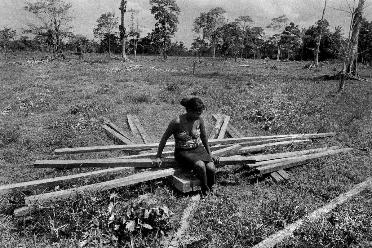 Paula Lance sits on the remains of the house that she and her husband were building on land that was taken from them by paramilitaries and then returned to her by court order. 