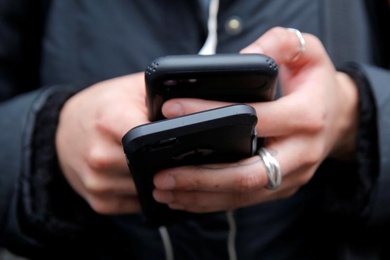 A woman uses her cell phones in Manhattan, New York, U.S., January 30, 2018.