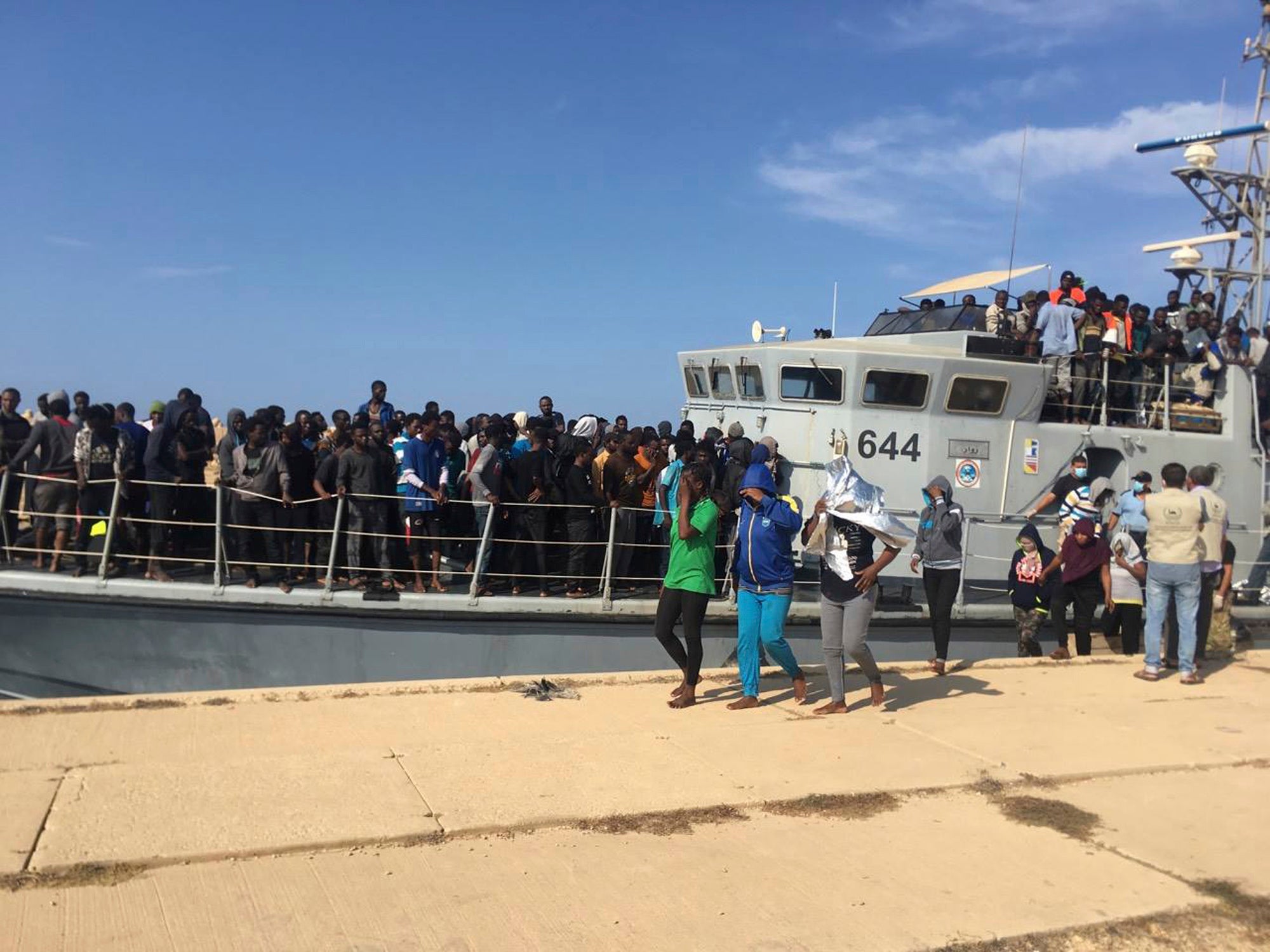 Photo released by the Libyan Coast Guard showing people disembarking in Libya after being intercepted offshore, June 24, 2018. 