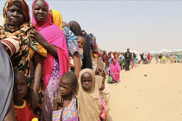 Families displaced by the Boko Haram insurgency line up for food being distributed by International Medical Corps in northeast Nigeria's Borno state on January 29, 2018 in Maiduguri, Nigeria.