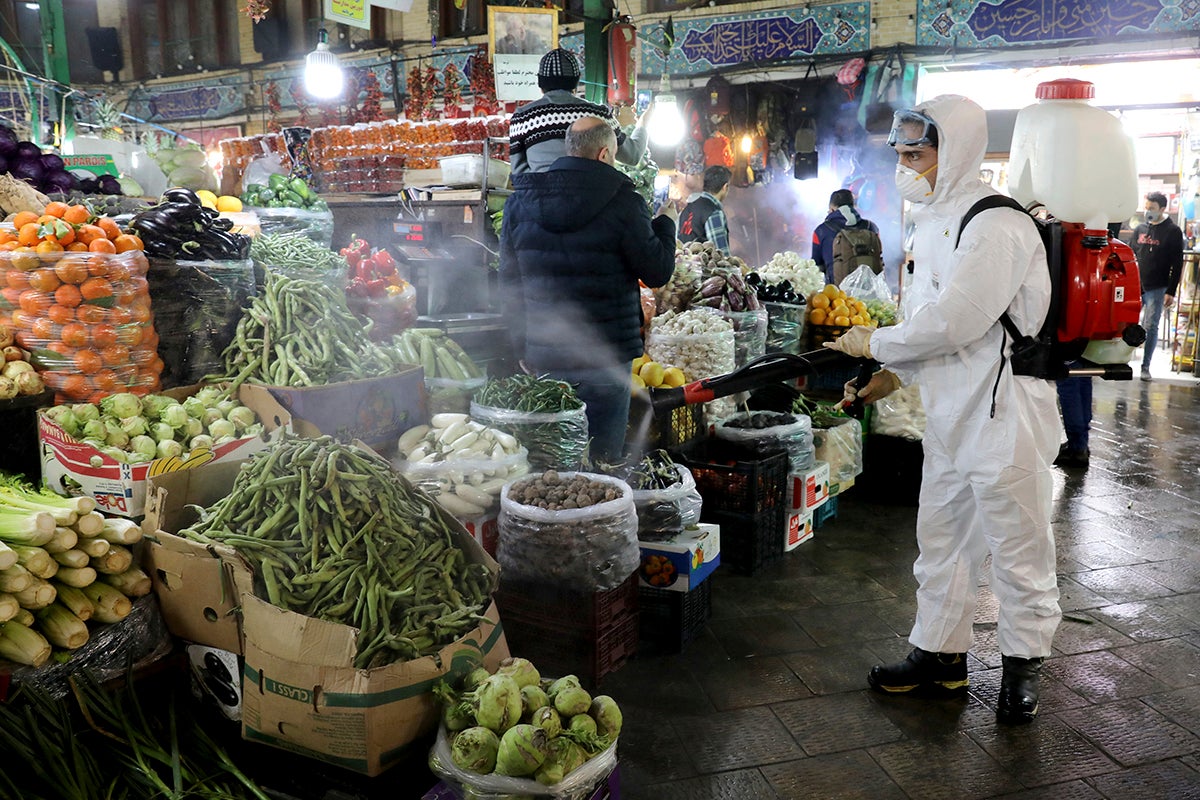 A firefighter disinfects a traditional shopping center to help prevent the spread of the new coronavirus in northern Tehran, Iran.