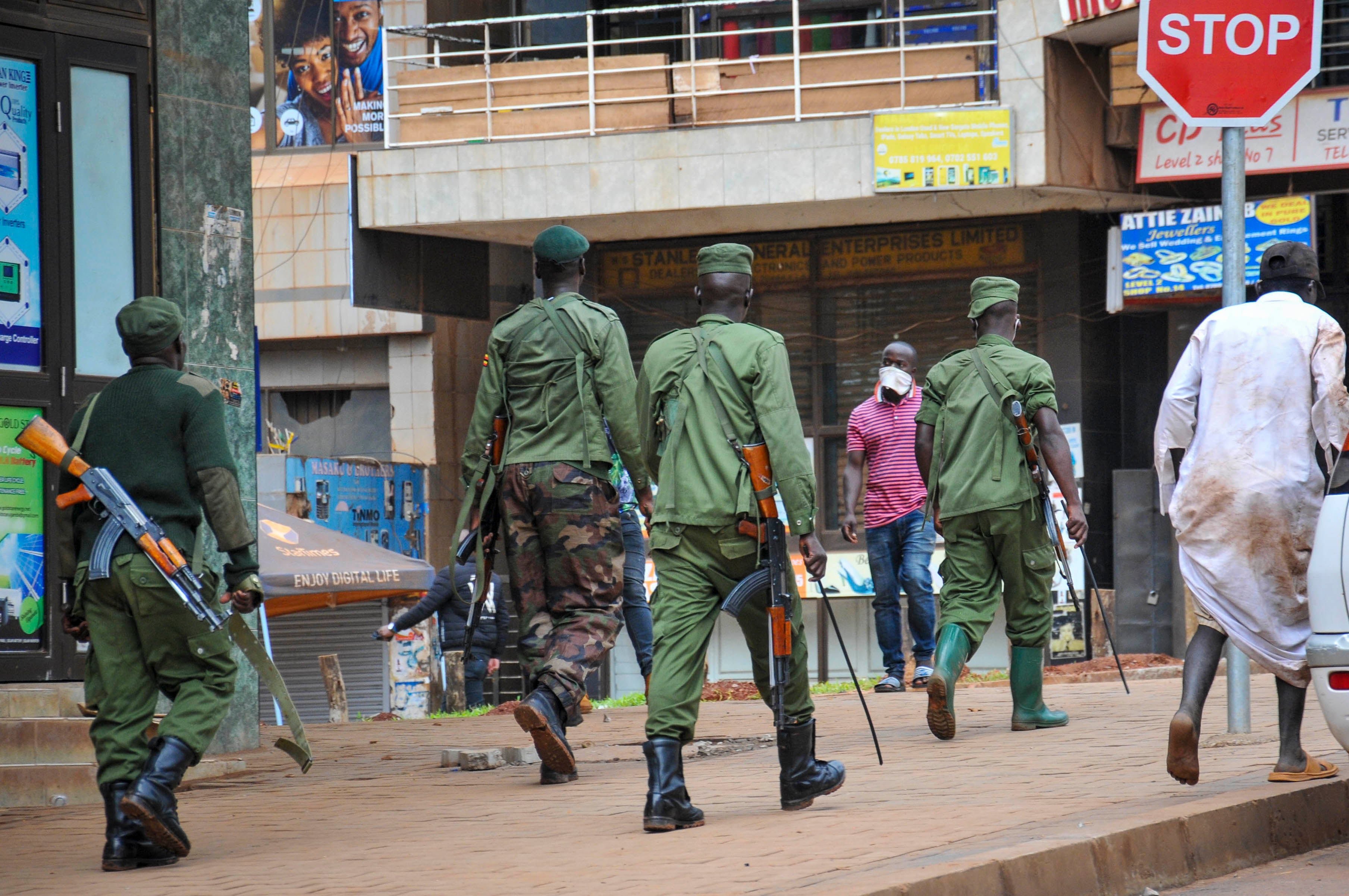 Ugandan police and other security forces chase people off the streets, after police cleared a stand of motorcycle taxis which are no longer permitted to operate after all public transport was banned for two weeks to halt the spread of the new coronavirus,