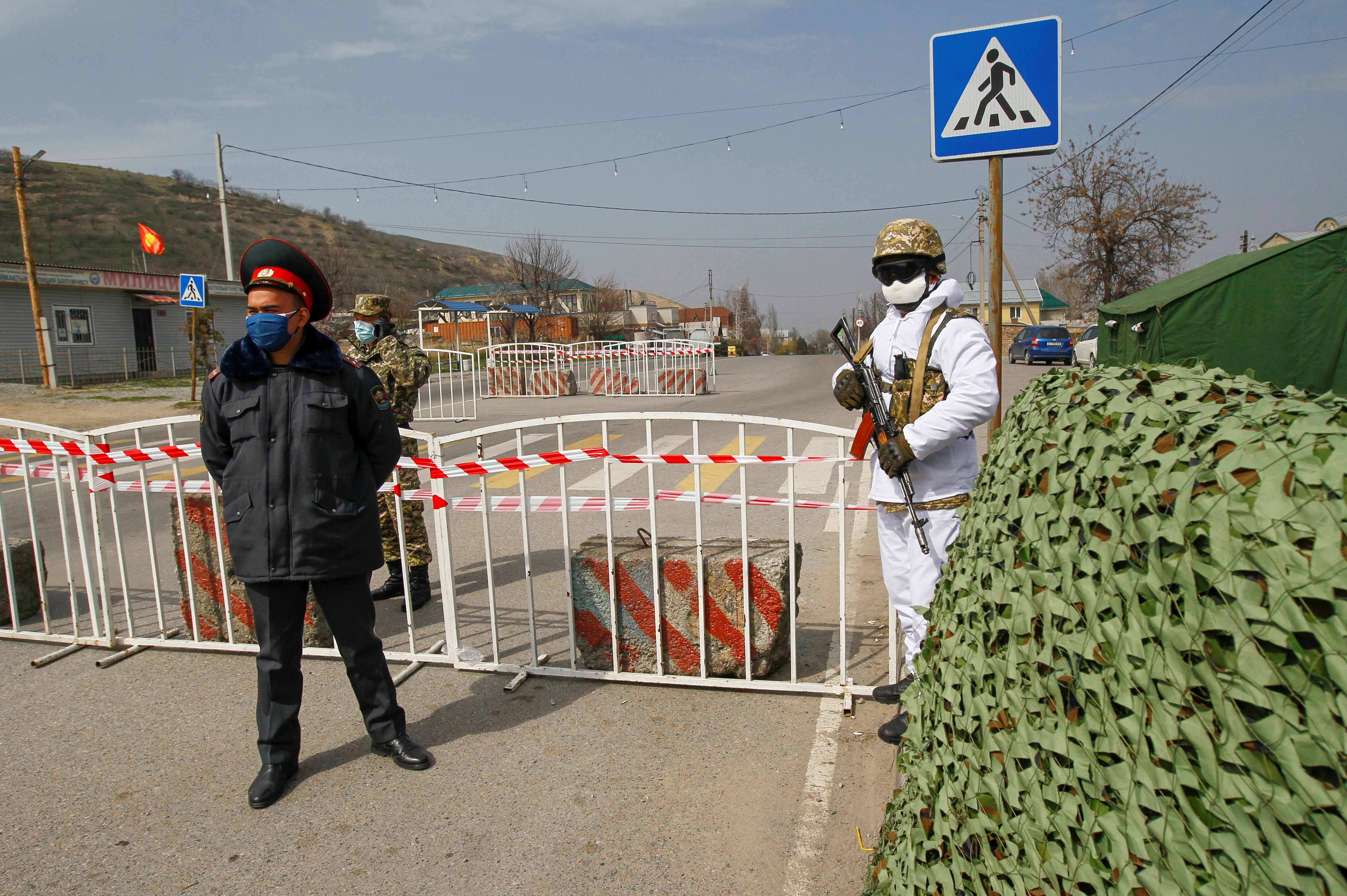 Kyrgyz law enforcement officers verify drivers and passengers' documents at a check point, after authorities declared a state of emergency in the capital Bishkek.