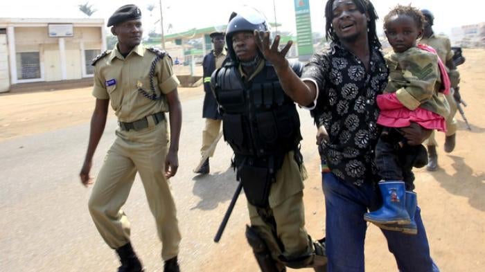 Police arrest a man with a child in a suburb of Kampala on September 11, 2009.