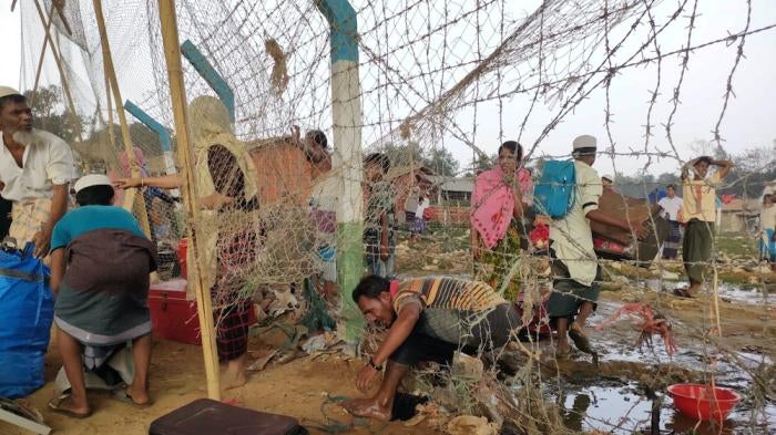 A man climbs through barbed wire fencing at a Rohingya refugee camp in Cox’s Bazar, Bangladesh, as a massive fire swept through the camps on March 22, 2021.