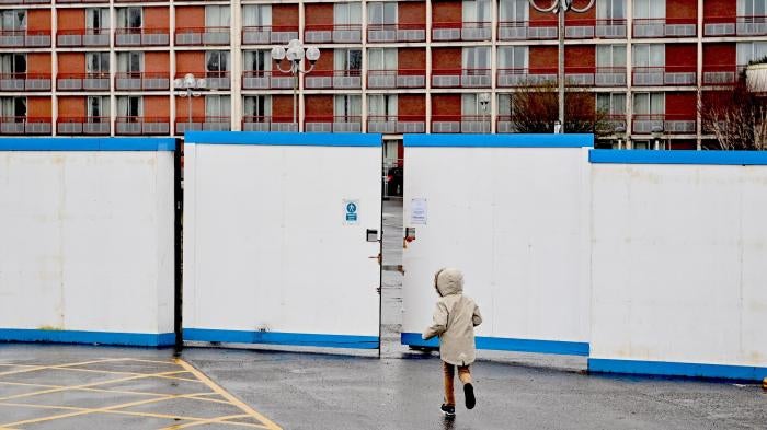 A child plays outside the gates of a hotel
