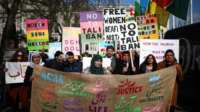 Protesters hold placards at a demonstration calling for women's rights in Afghanistan
