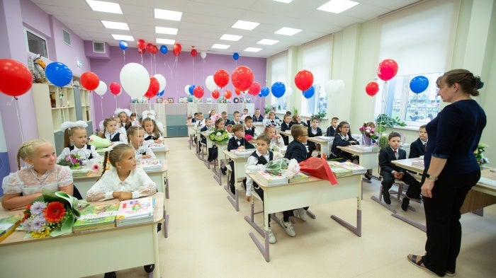 Children sit at desks in a classroom 