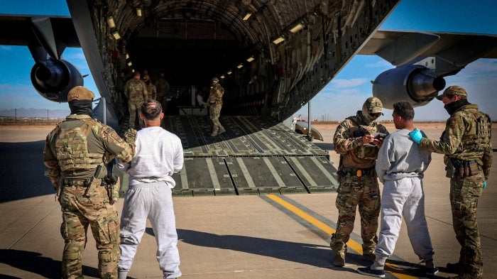 The first US military aircraft to carry detained migrants to a detention facility at Guantanamo Bay is boarded from an unspecified location in the US, February 4, 2025.