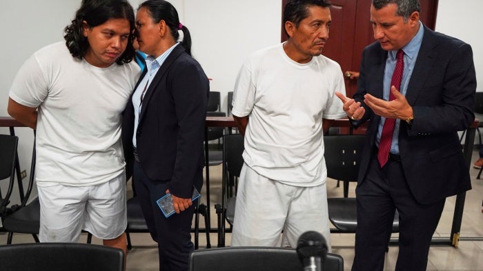 Alejandro Henríquez, left, and José Ángel Pérez, right, speak with their lawyers before their first court hearing in Santa Tecla, El Salvador, May 30, 2025.
