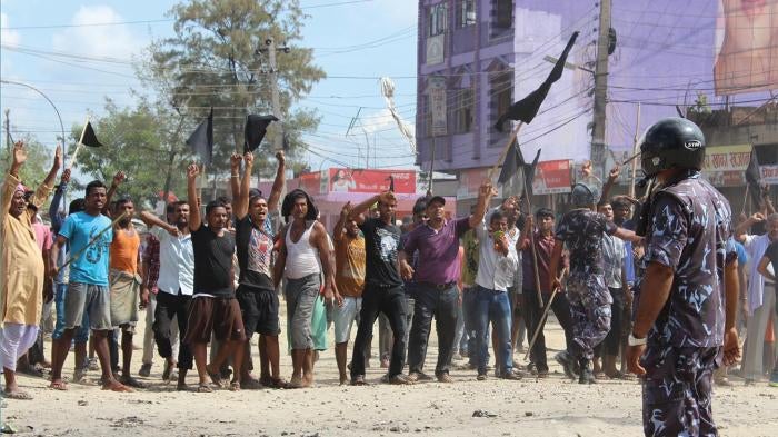 A police officer faces protesters